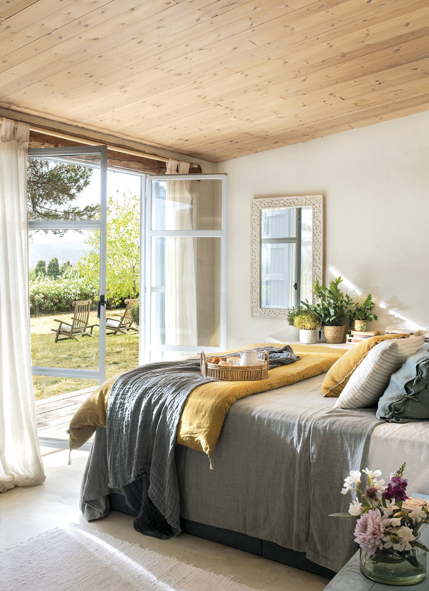 Dormitorio mediterráneo y veraniego con techo de madera.