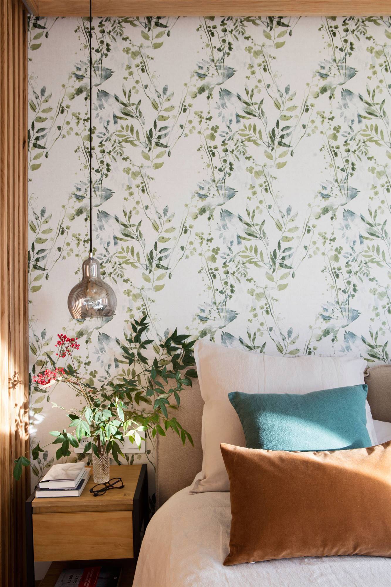 Dormitorio con papel pintado de flores en la pared del cabecero.