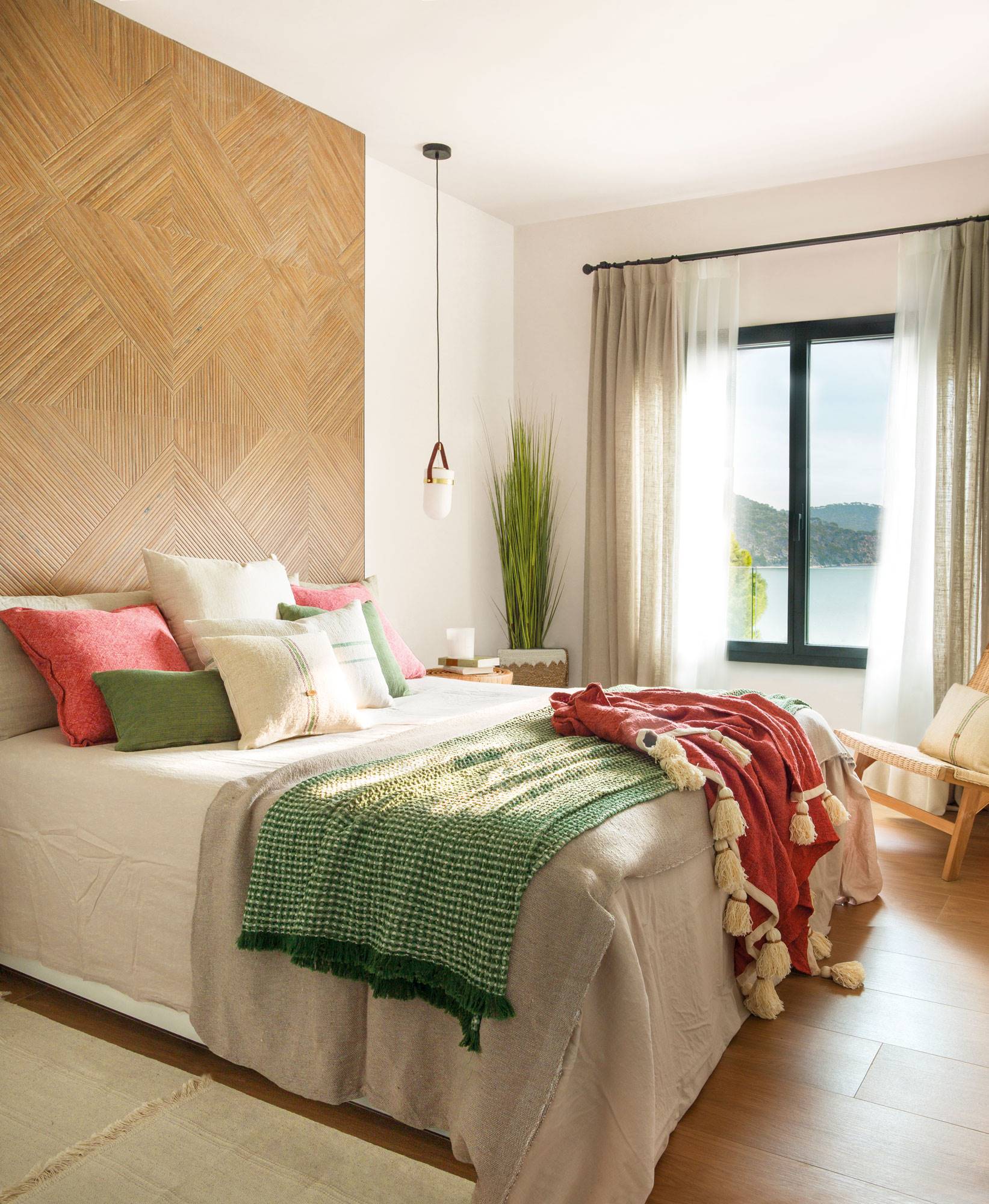 Dormitorio con cabecero revestido con baldosa con acabado en madera.