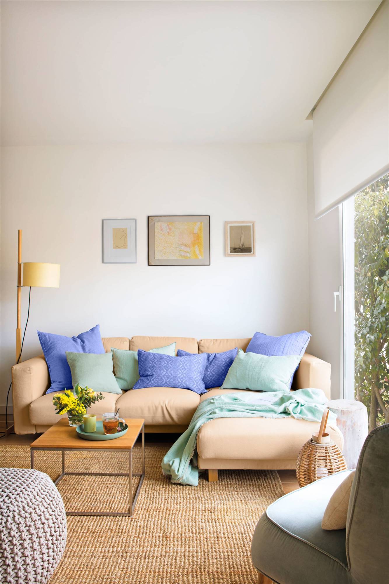 Salón con sofá beige y cojines azules. 