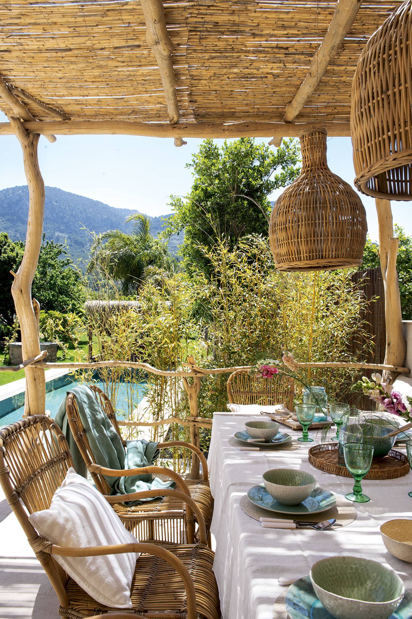 Comedor porche exterior rodeado de plantas de estilo mediterráneo. 