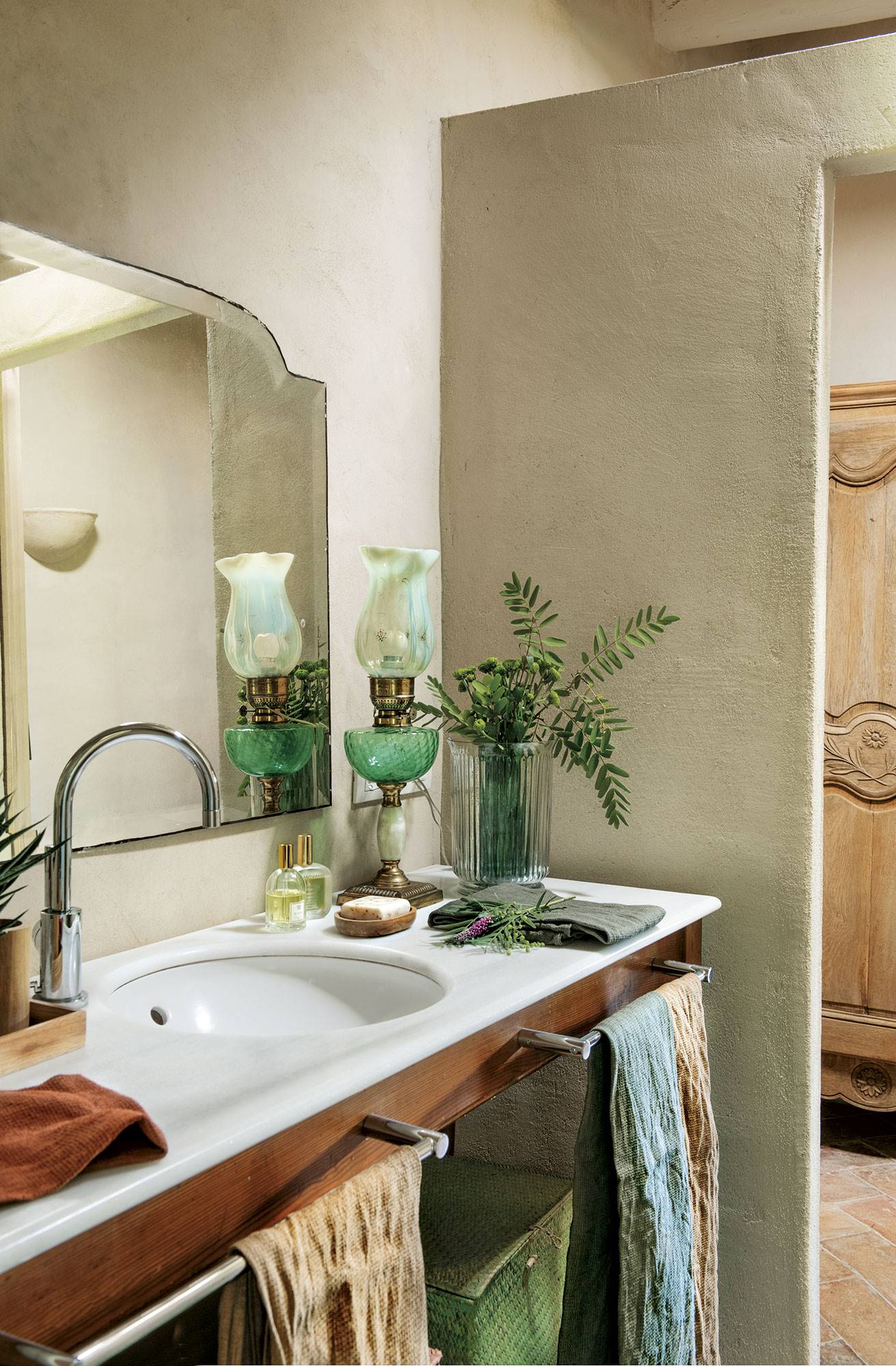 Baño con mueble de madera, lavamanos de mármol, espejo antiguo y vestidor