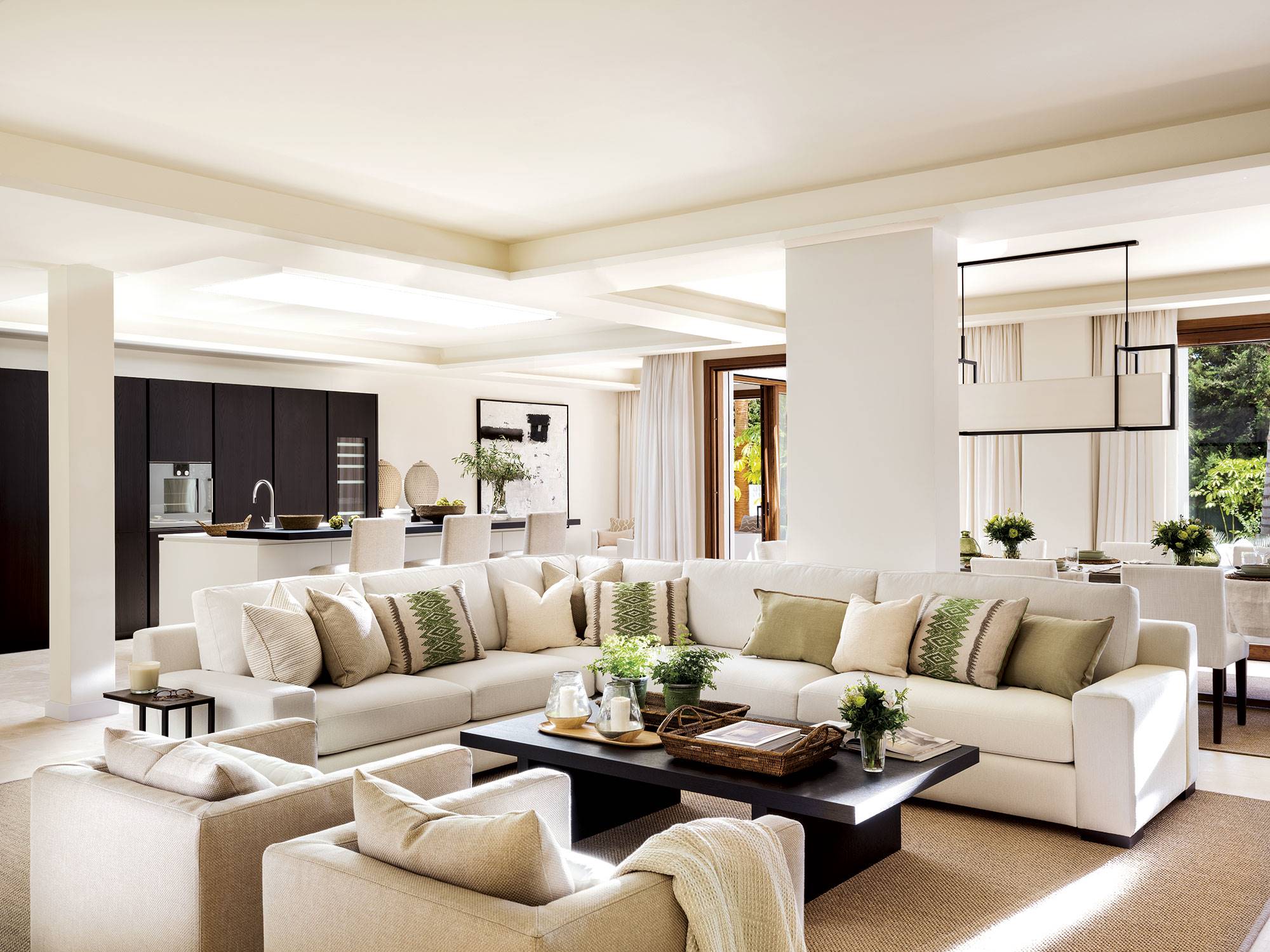 Salón interior en tonos beiges, sofá blanco esquinero y butacas.