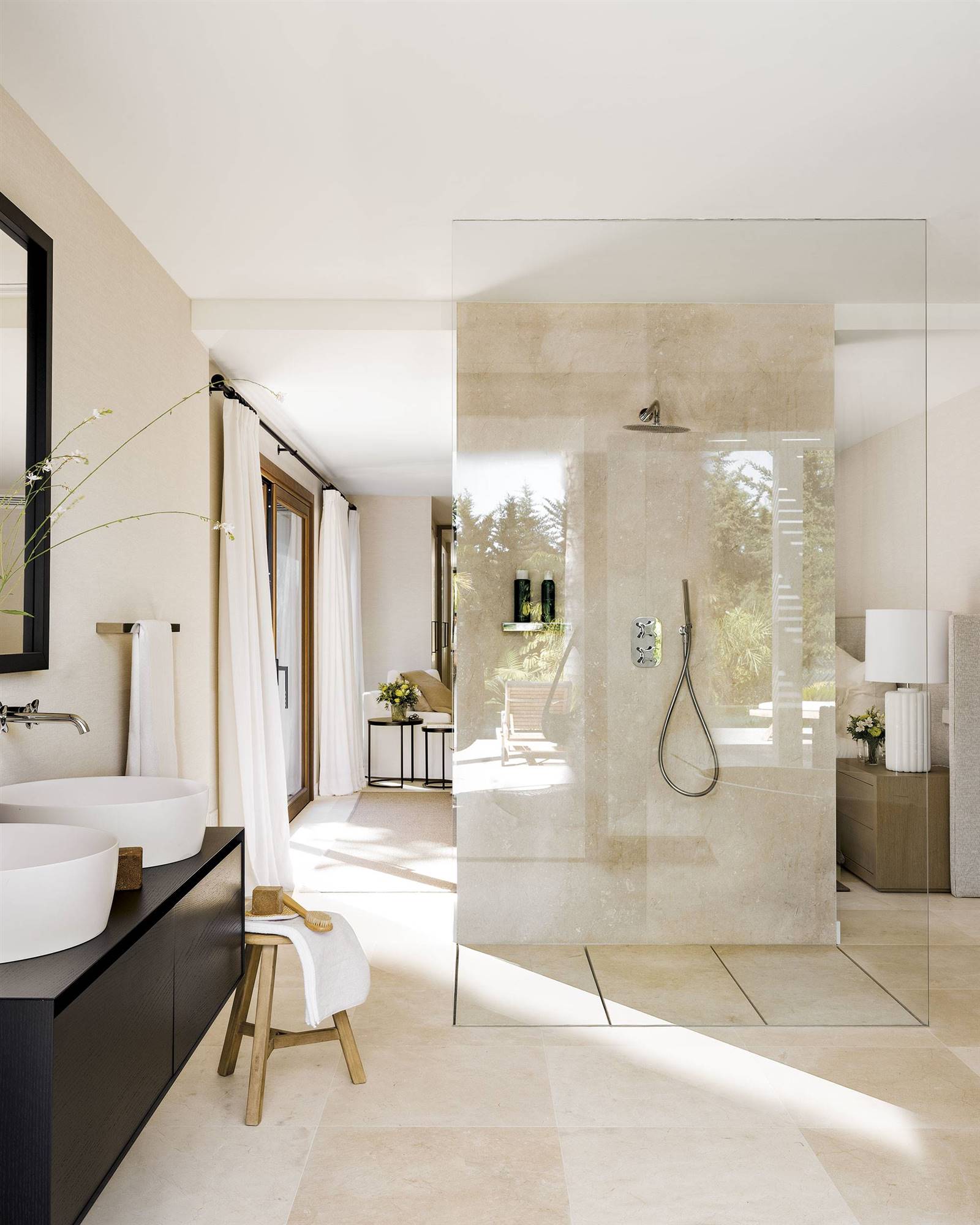 Baño en suite con ducha con mampara de cristal en el centro de la estancia. 