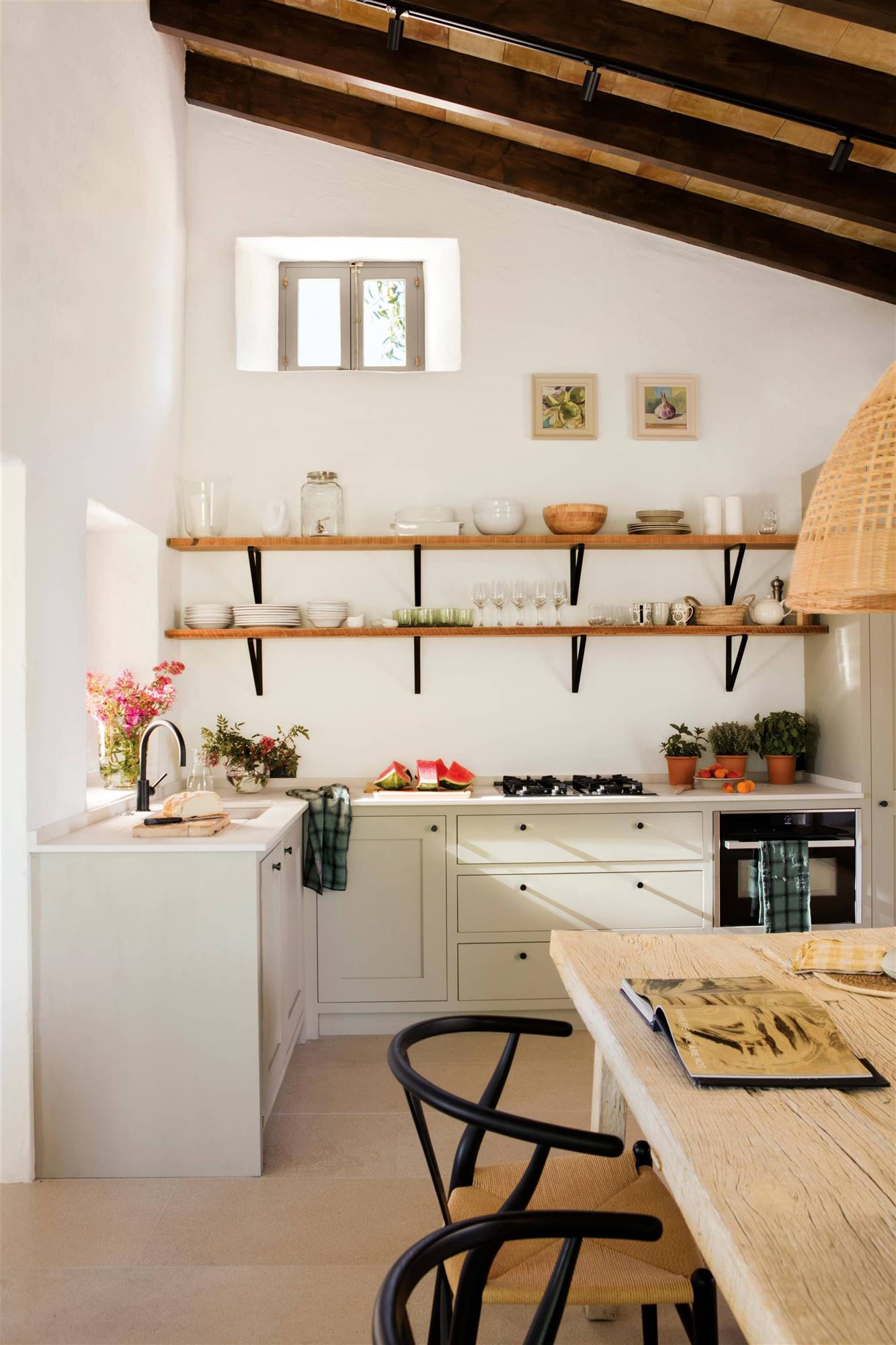 Una cocina de estilo rústico con muebles blancos y estantes de madera con escuadras. 