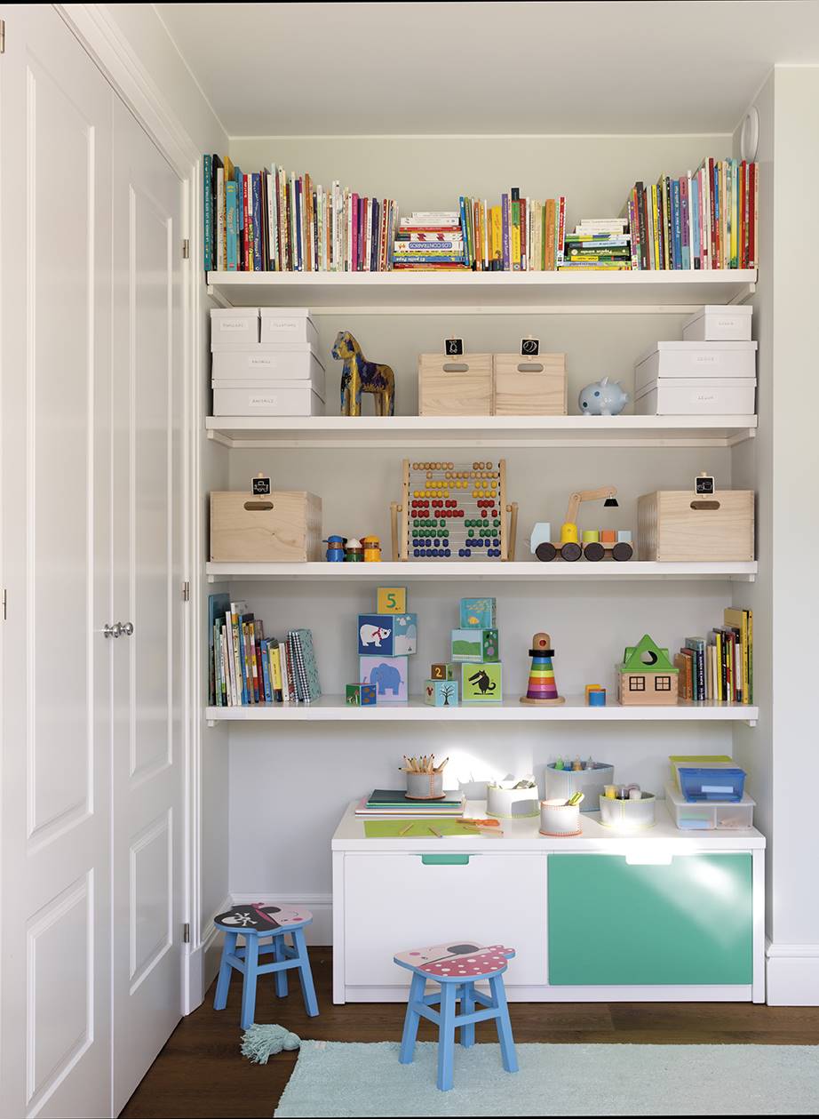 Estantería ordenada con libros y juguetes en habitación infantil. 