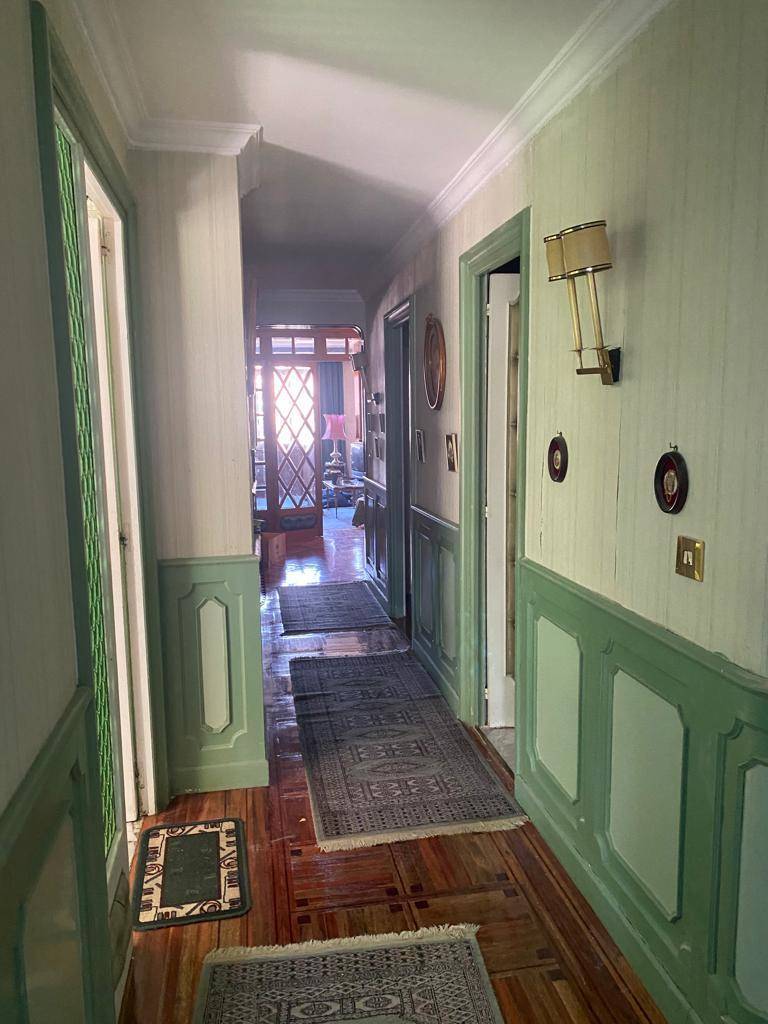 Antes recibidor con arrimadero en verde y paredes con papel pintado.