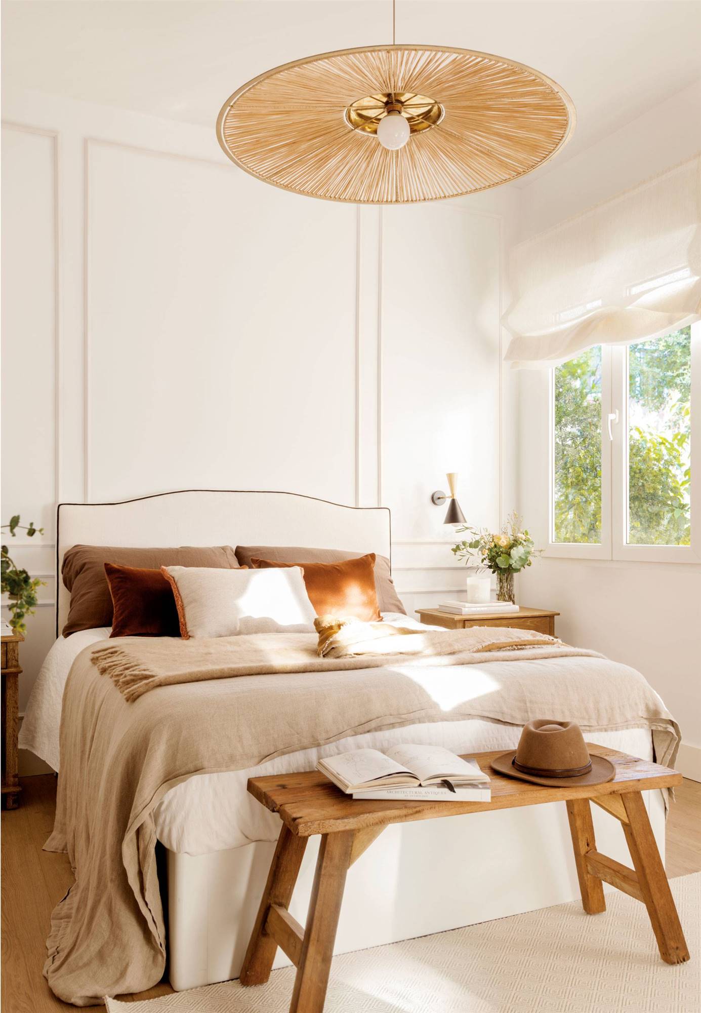 Dormitorio decorado en blanco y madera con lámpara de techo de fibra natural. 