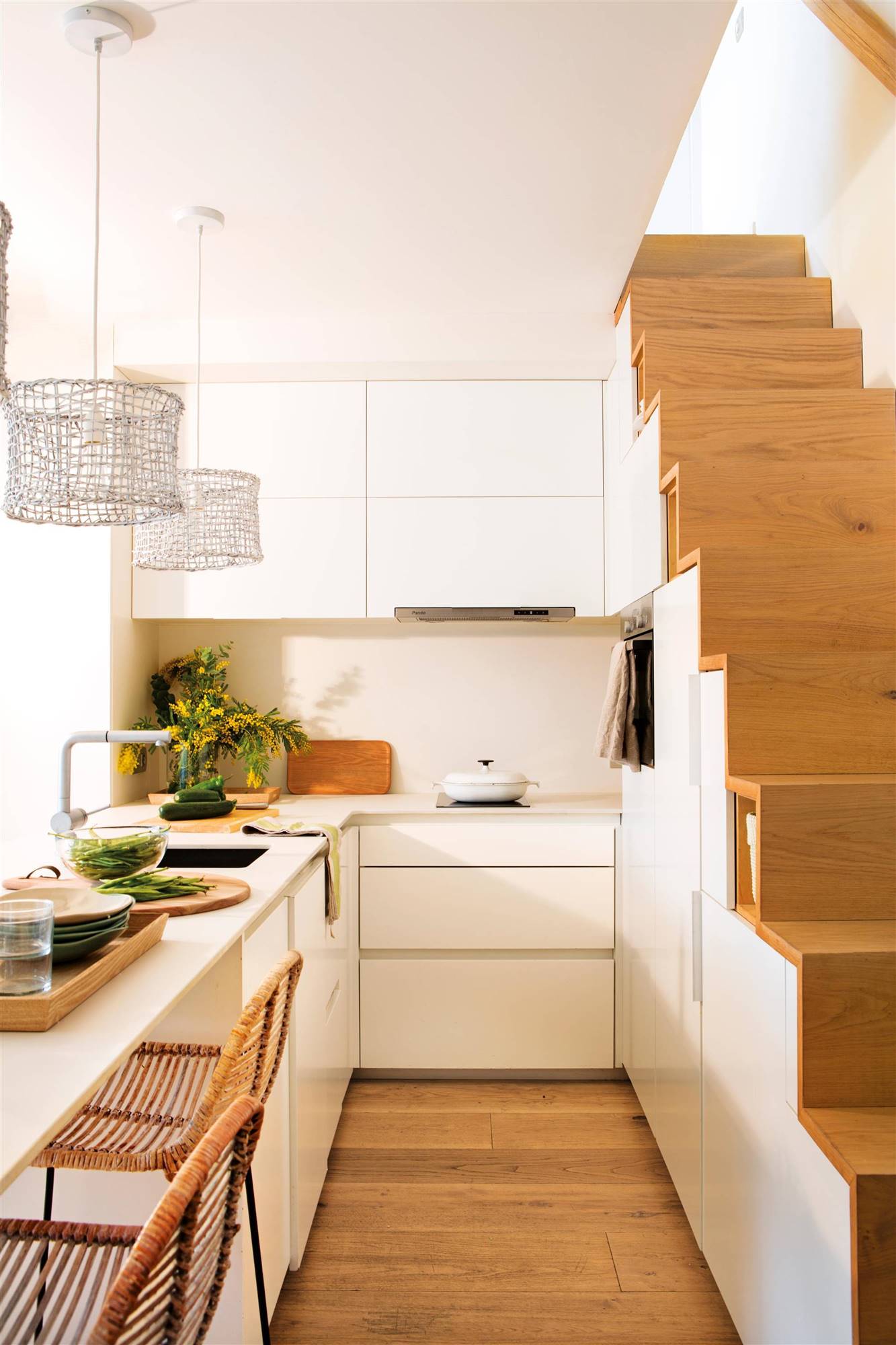  Cocina blanca con armarios en la escalera.