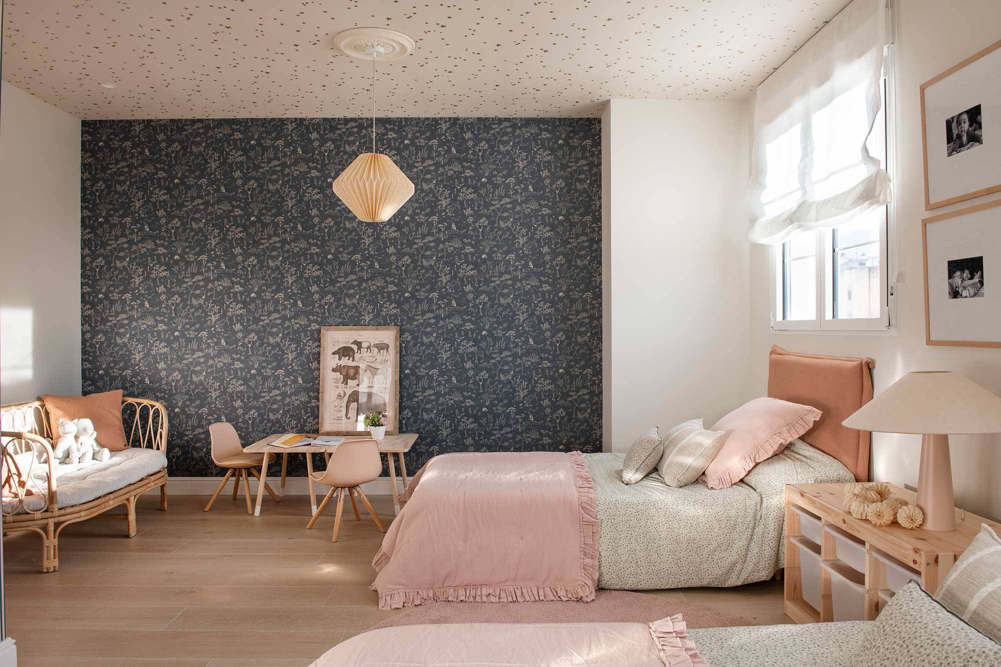 Habitación infatil con dos camas y papel pintado en la pared