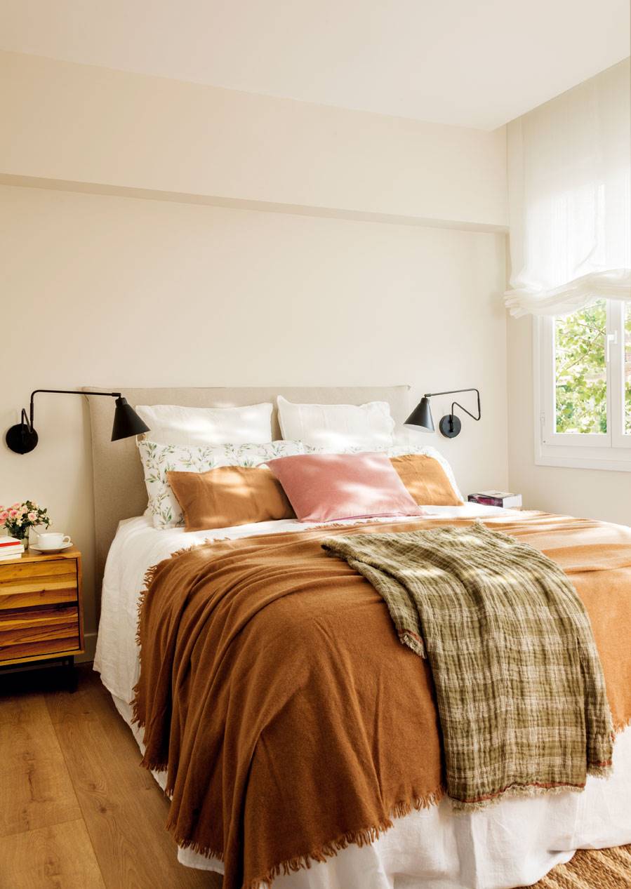 Dormitorio vestido en tonos cálidos sobre una base neutra. 