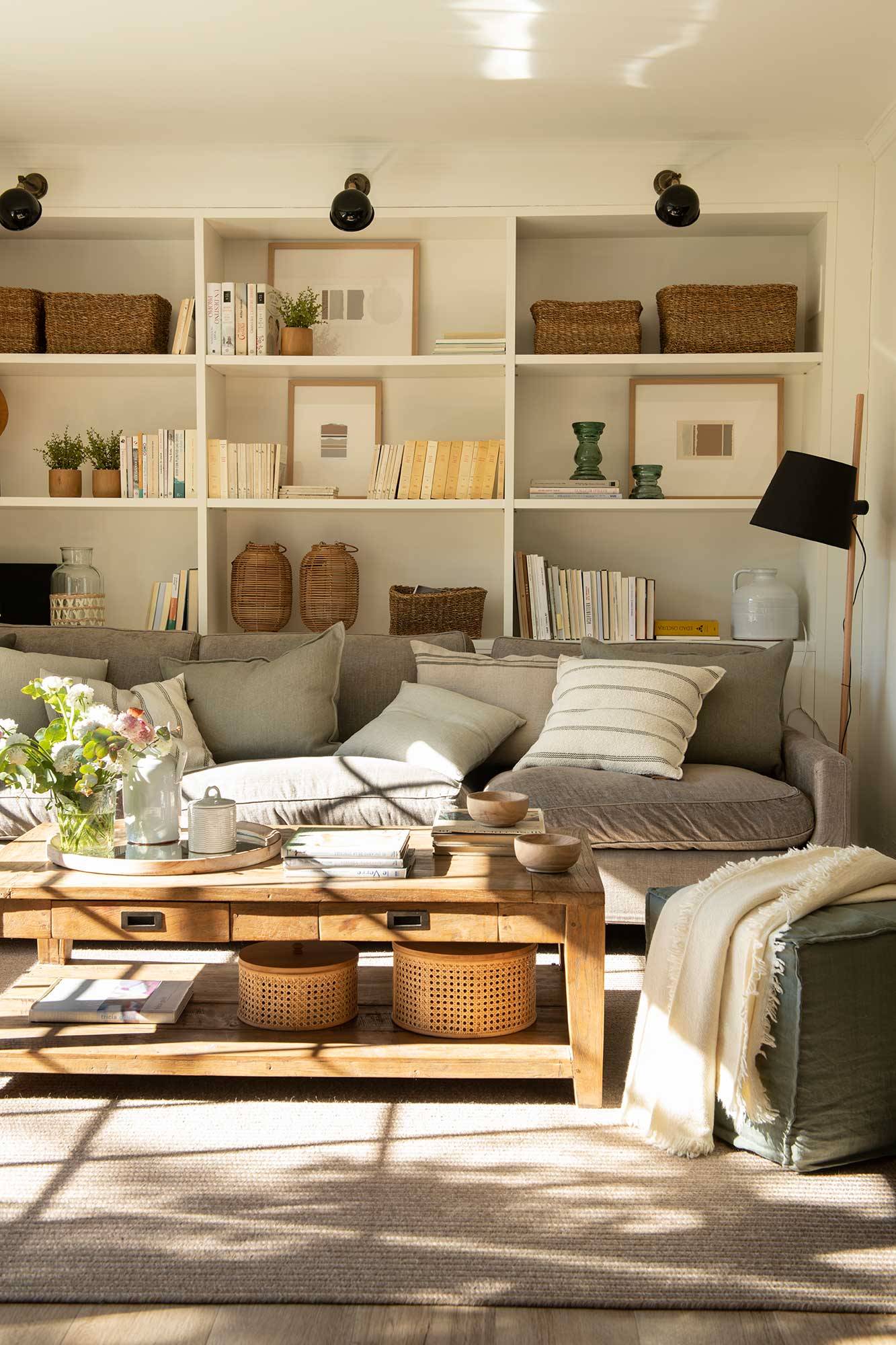 Salón con sofá gris y librería 