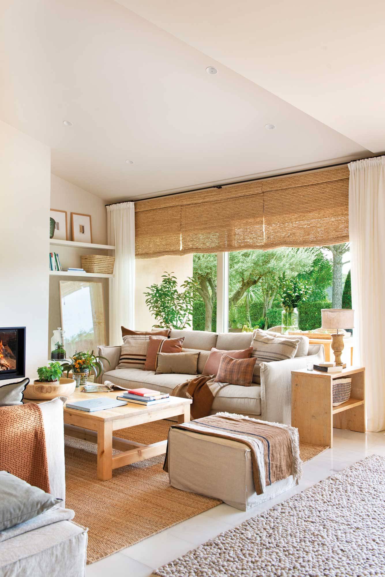 Salón diseñado por Marta Tobella con sofá neutro de lino y fibra vegetal en alfombra y estores.