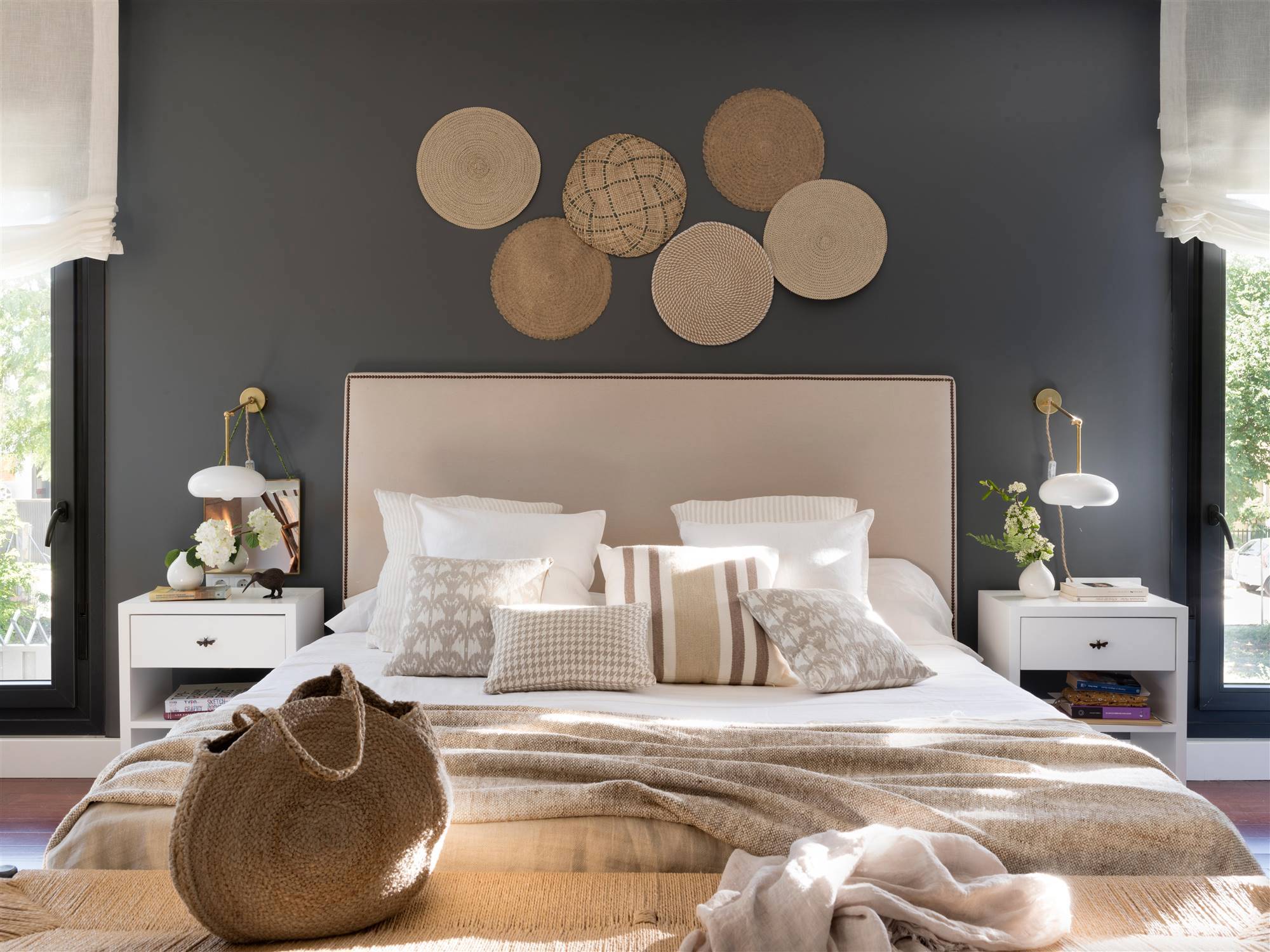 Dormitorio con pared del cabecero pintada en gris y decorada con individuales de fibra.