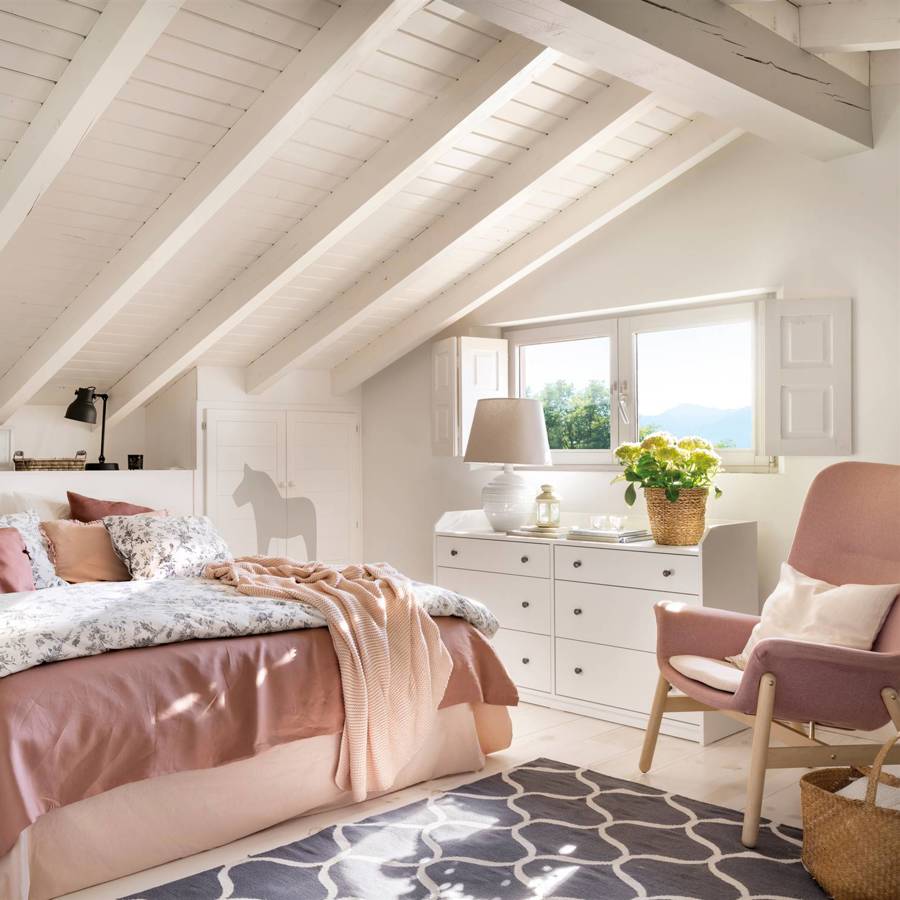 Dormitorio abuhardillado pintado en blanco con butaca rosa 00538485