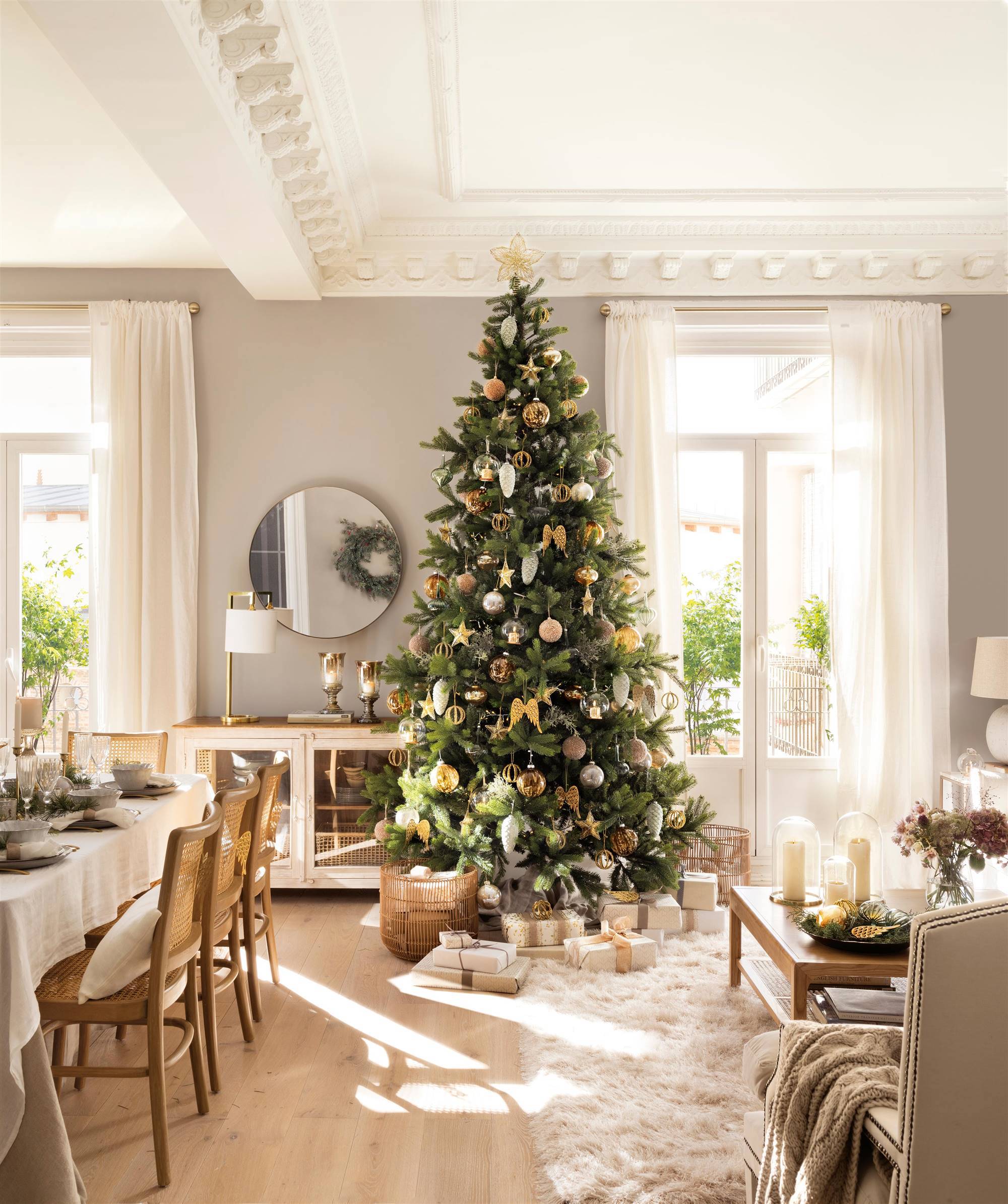 Salón decorado de Navidad con árbol con adornos dorados y plateados.