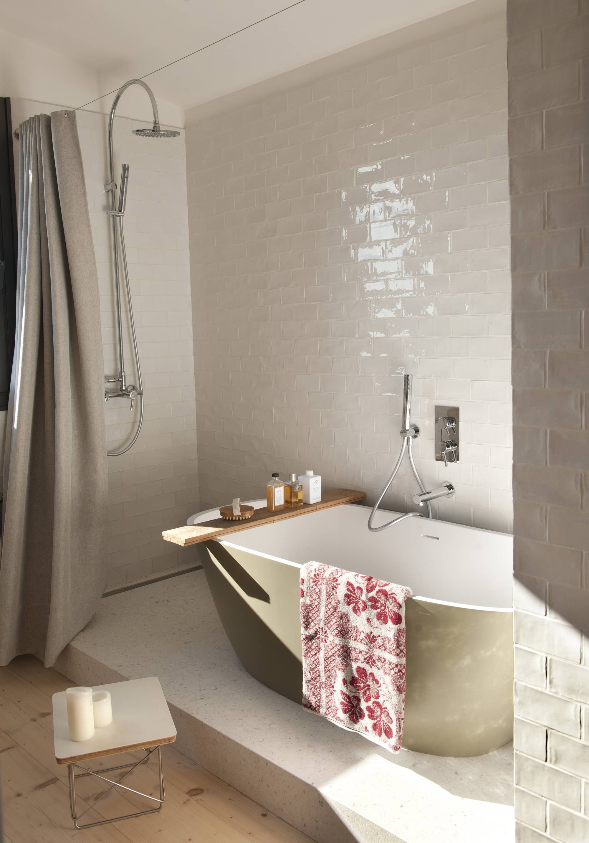 Baño con bañera exenta y ducha con cortina gris.