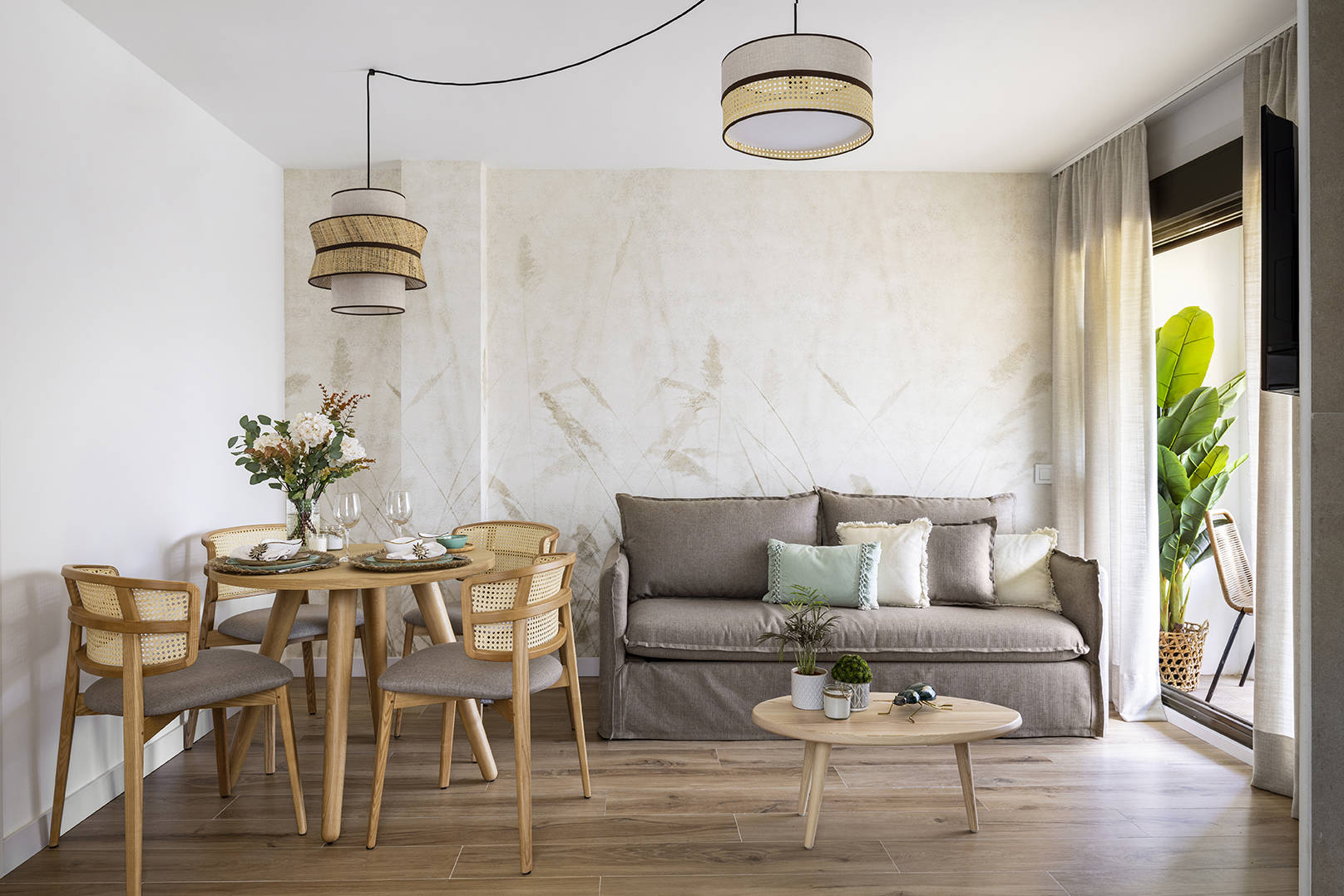 Piso pequeño con salón comedor decorado con papel pintado, mesa de madera y sofá cama por Alberto Torres PortobelloStreet.es