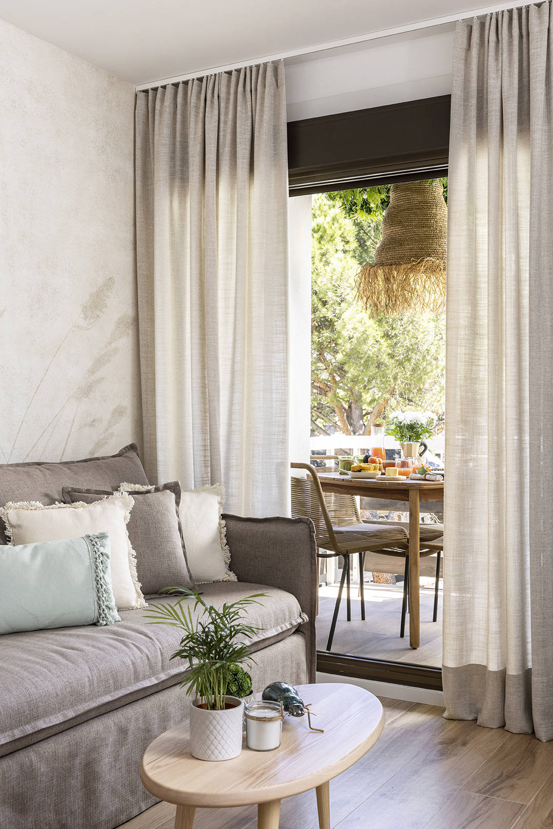 Piso pequeño con salón con sofá cama, mesita de madera y cortinas de lino por Alberto Torres PortobelloStreet