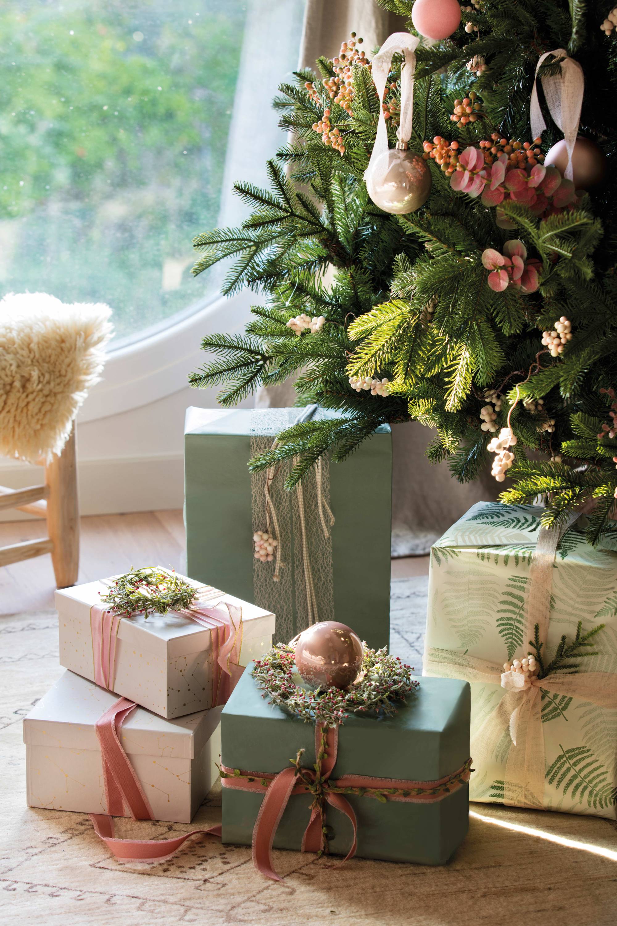 Regalos navideños sobre la alfombra, junto al árbol
