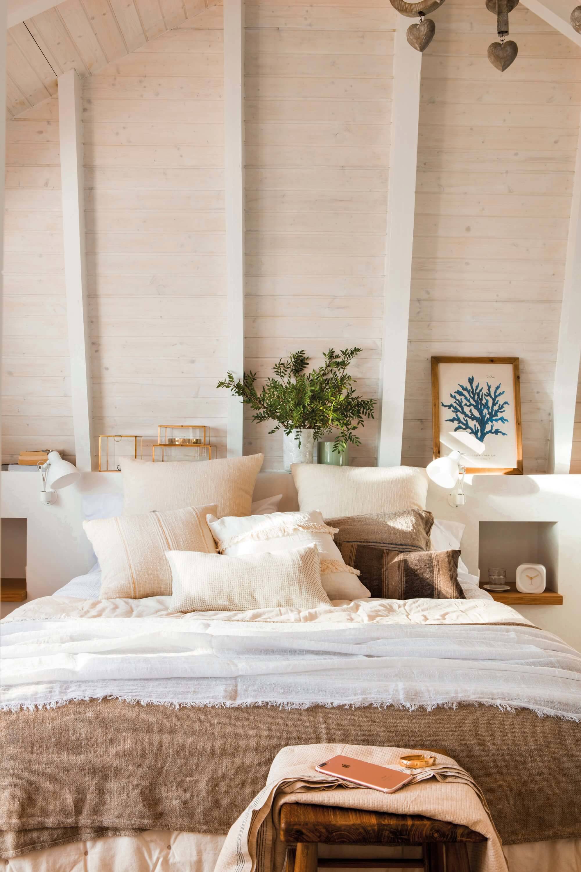 dormitorio blanco con vigas vistas.