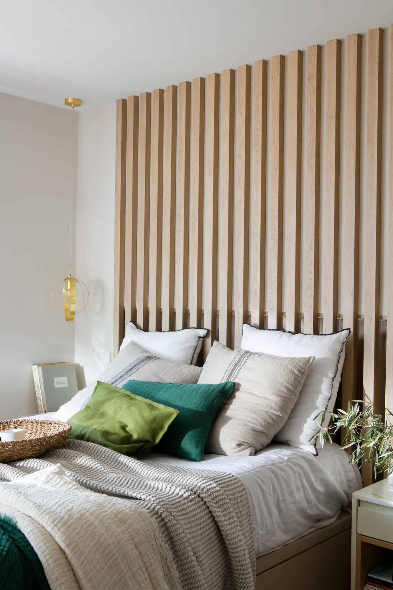 Dormitorio con cabecero con listones de madera. 