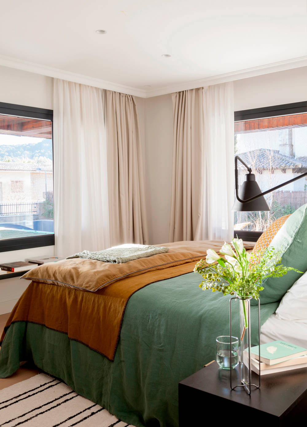 Dormitorio con doble cortinaje en las ventanas