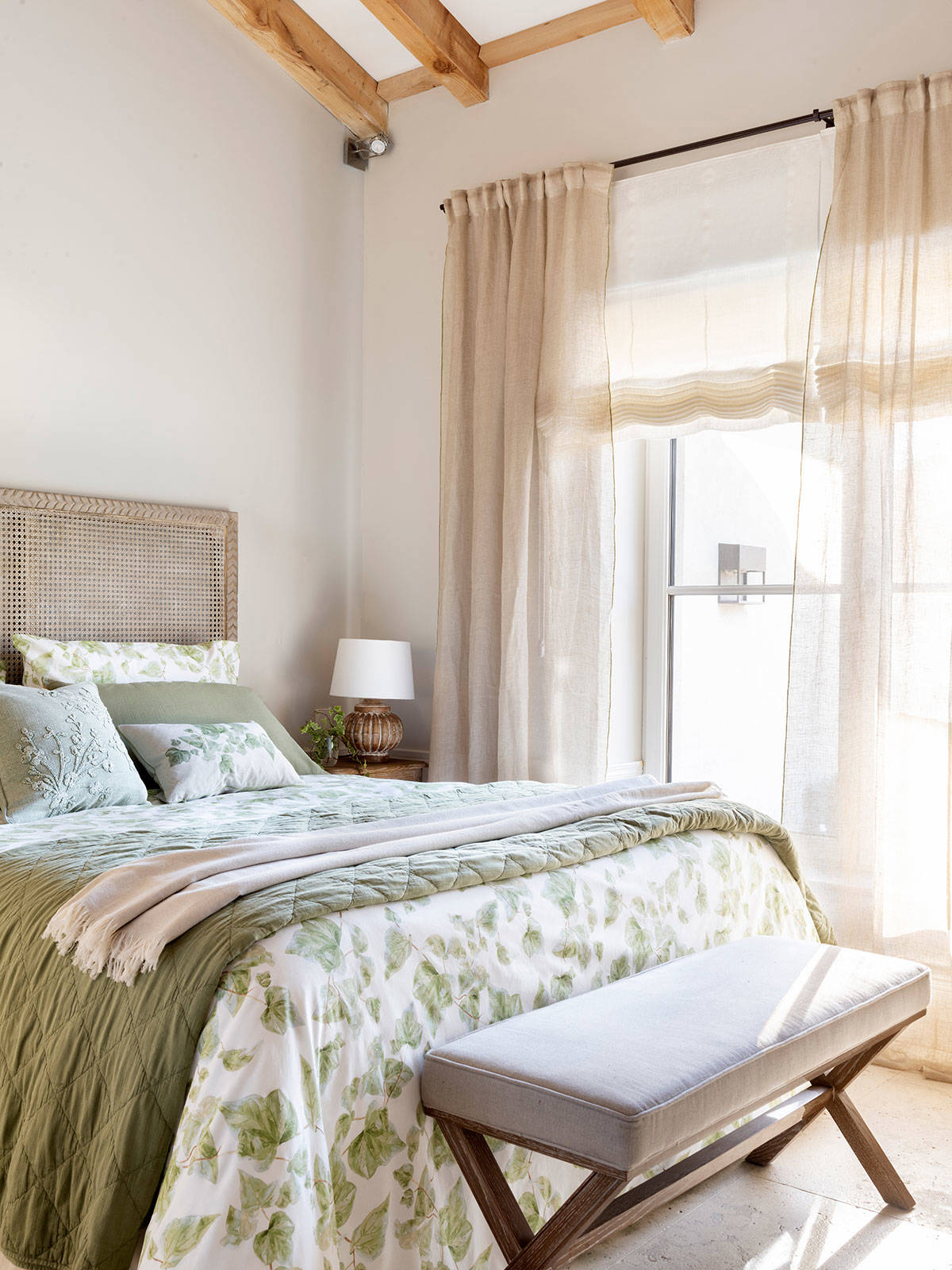 Dormitorio vestido con telas verdes lisas y estampadas.