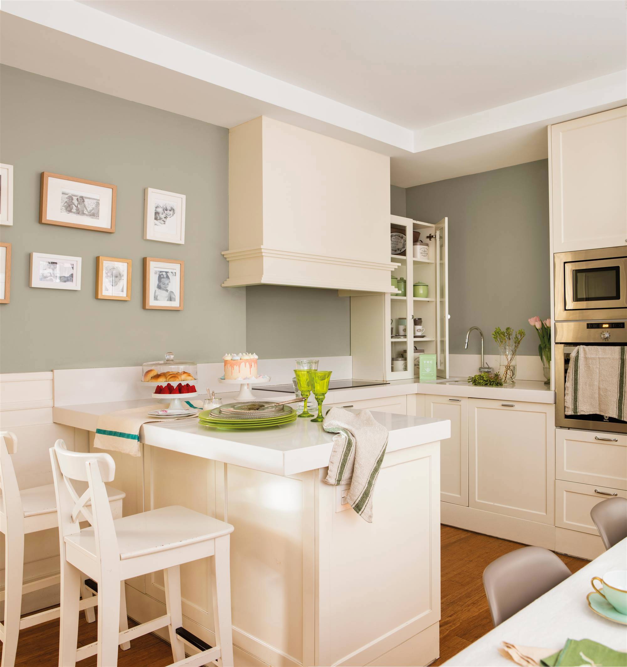 Cocina clásica de color blanco con paredes en verde suave y arrimadero a media altura. 