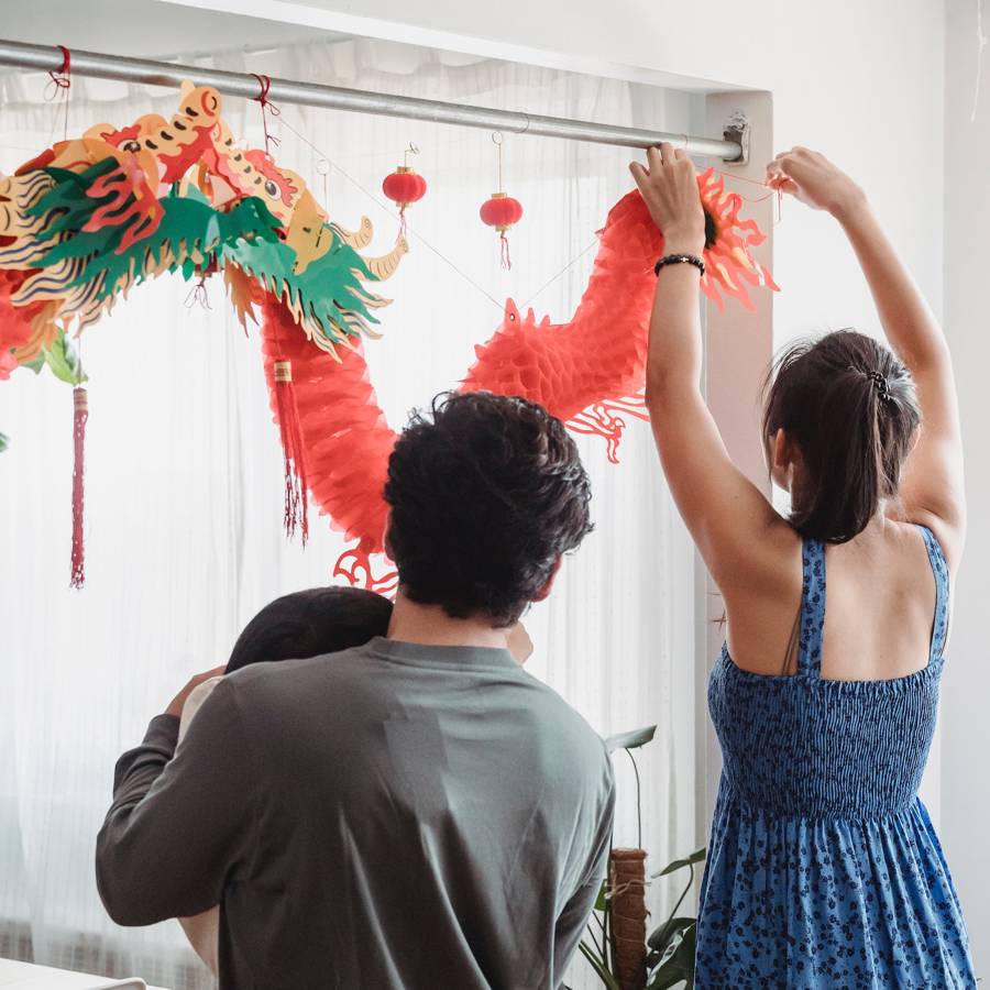 Una familia decorando la casa para el Año nuevo chino