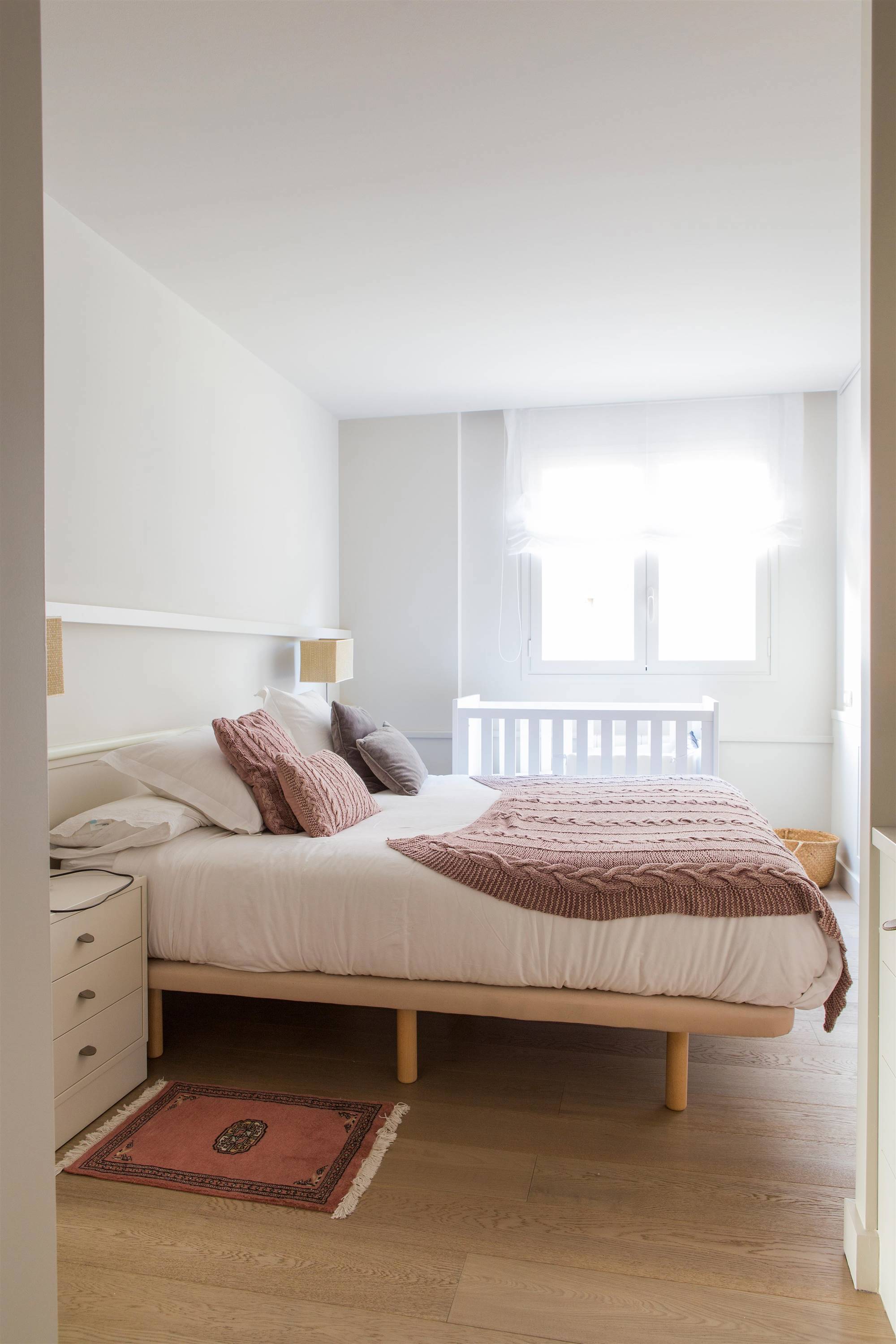 Dormitorio con cama alta y colcha en color rosa empolvado