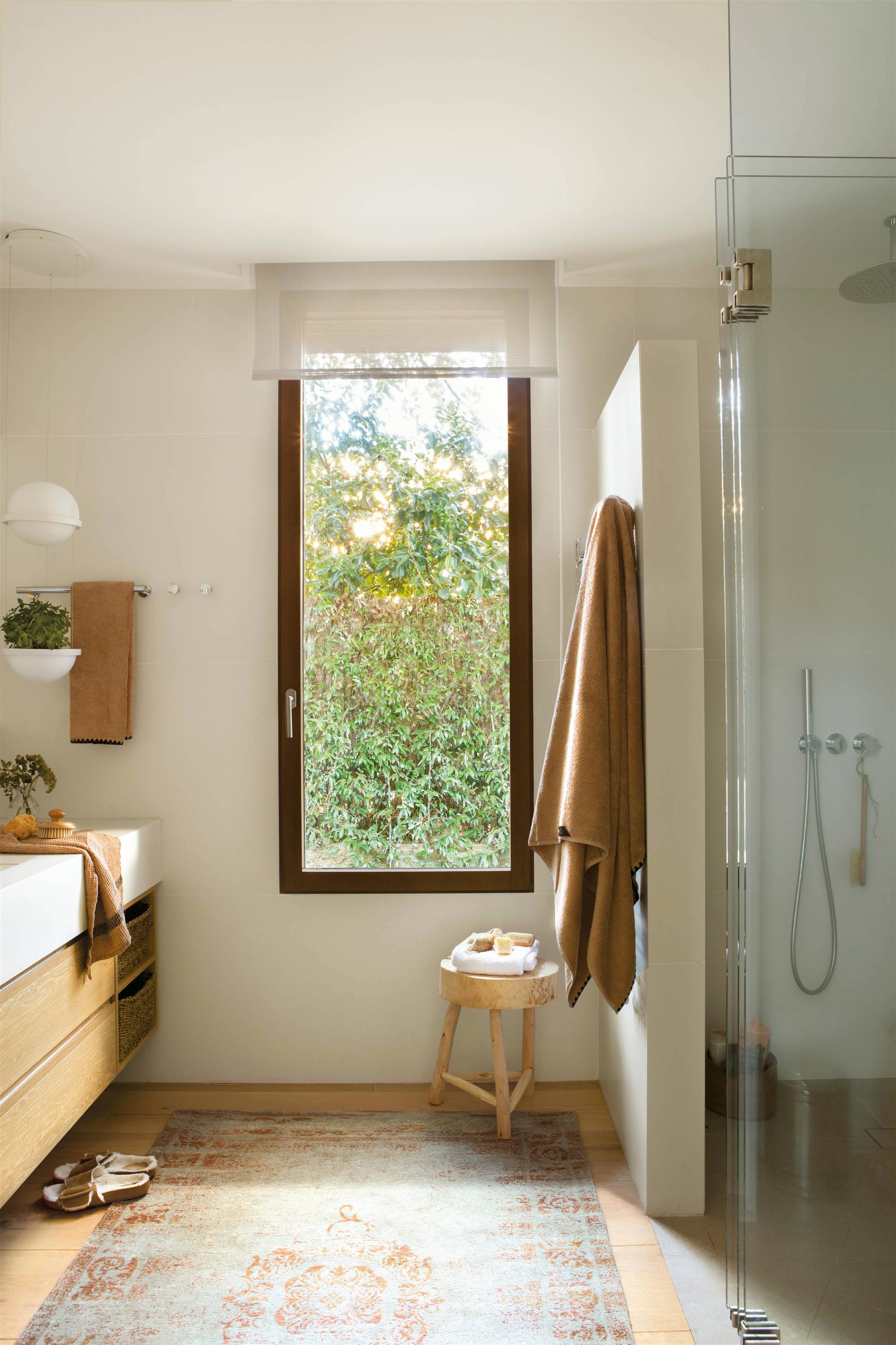 Baño grande con ventana, mueble de madera y ducha. 