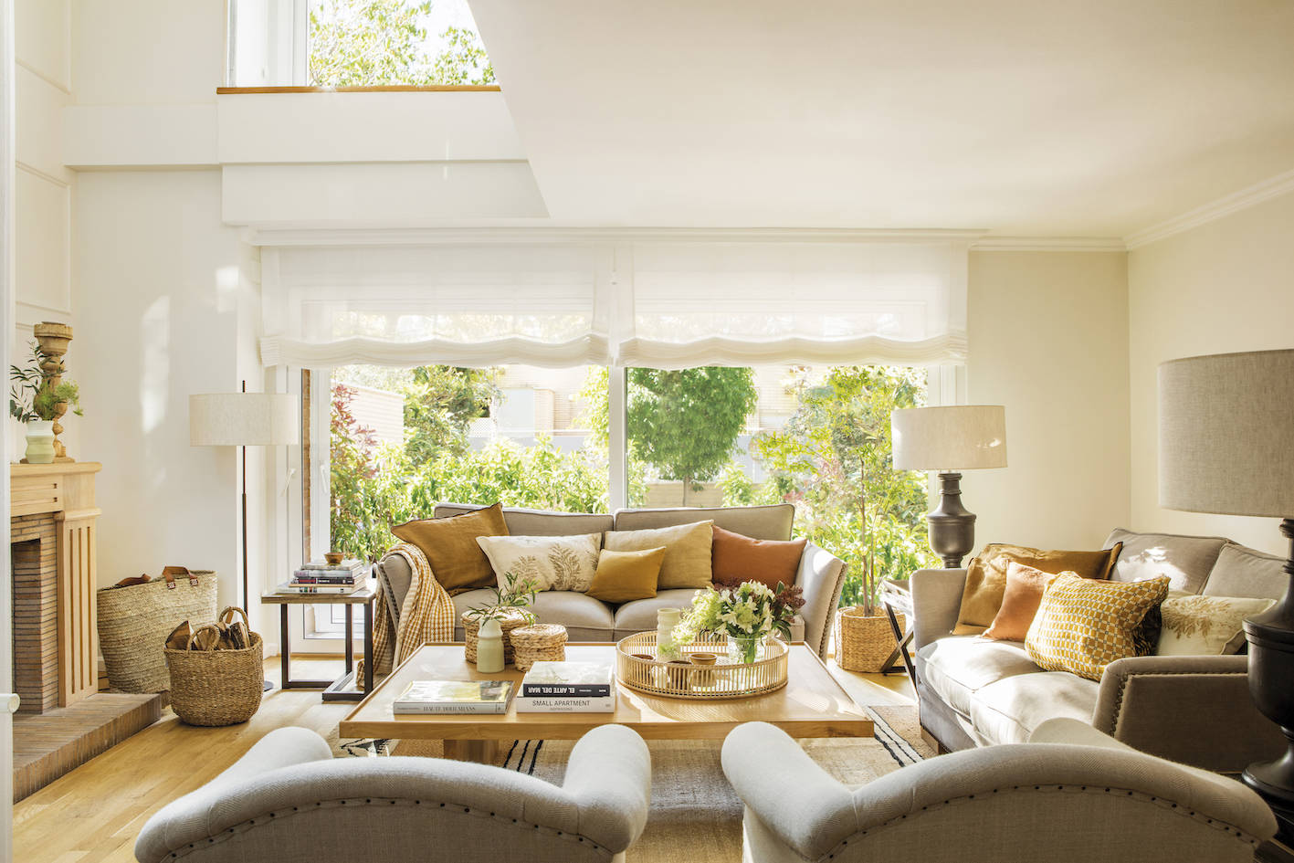 Salón clásico con sofás de color beige y estores blancos. 