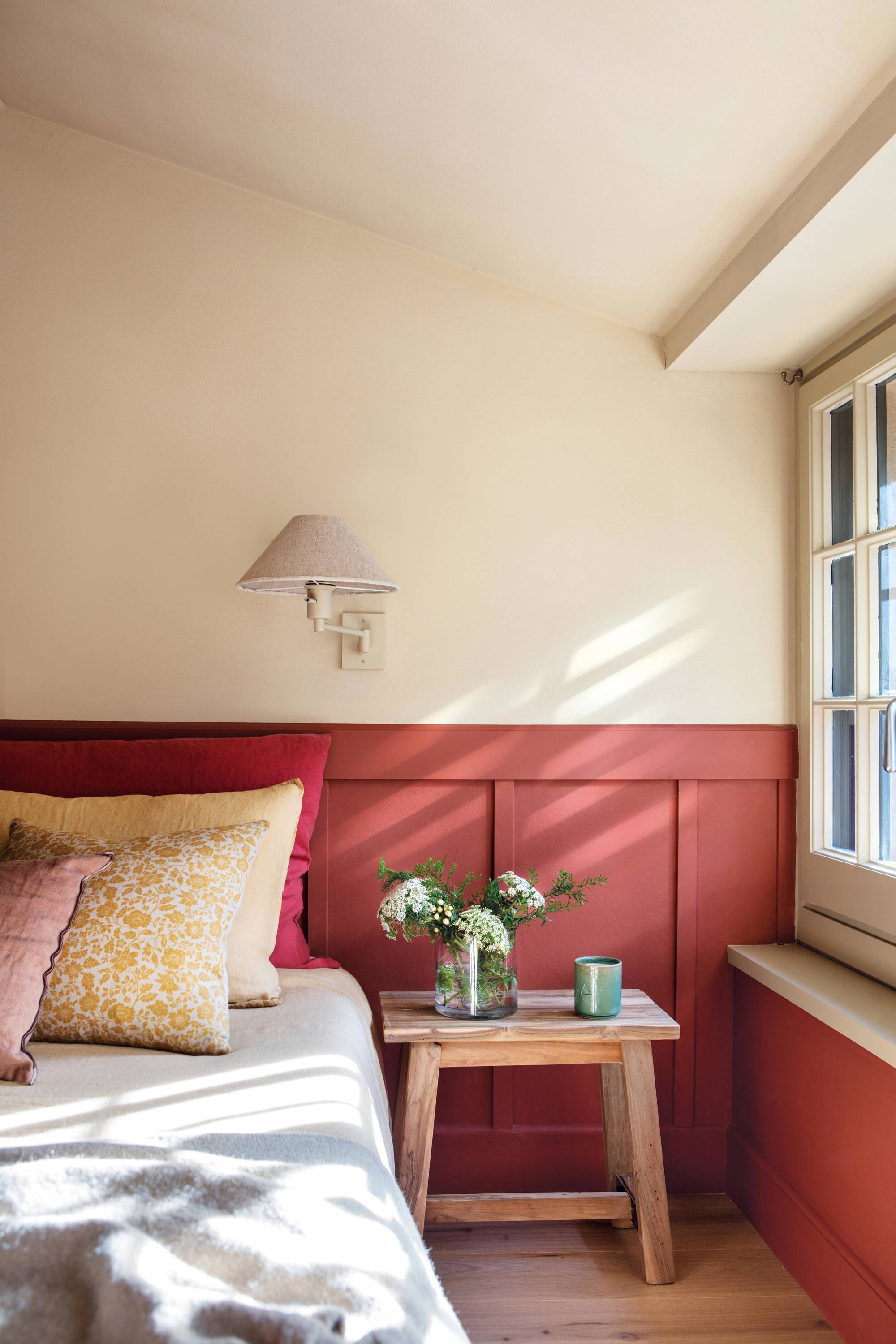 Dormitorio con arrimadero pintado en tono teja.