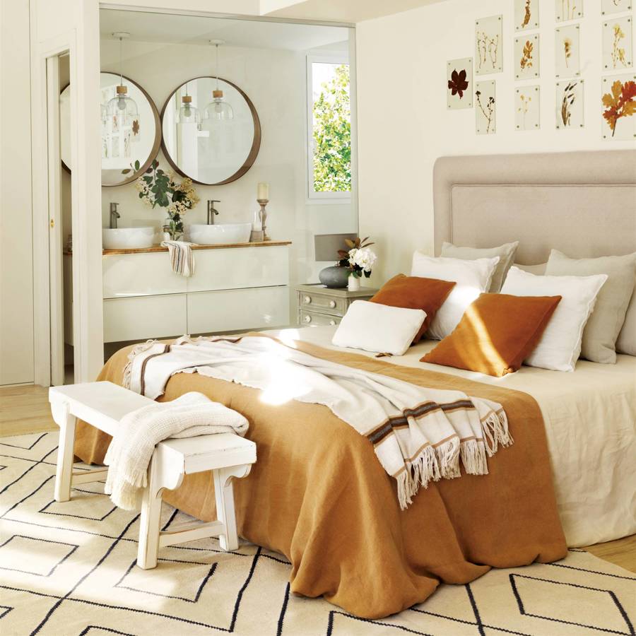 Dormitorio con cabecero tapizado y ropa de cama ocre 