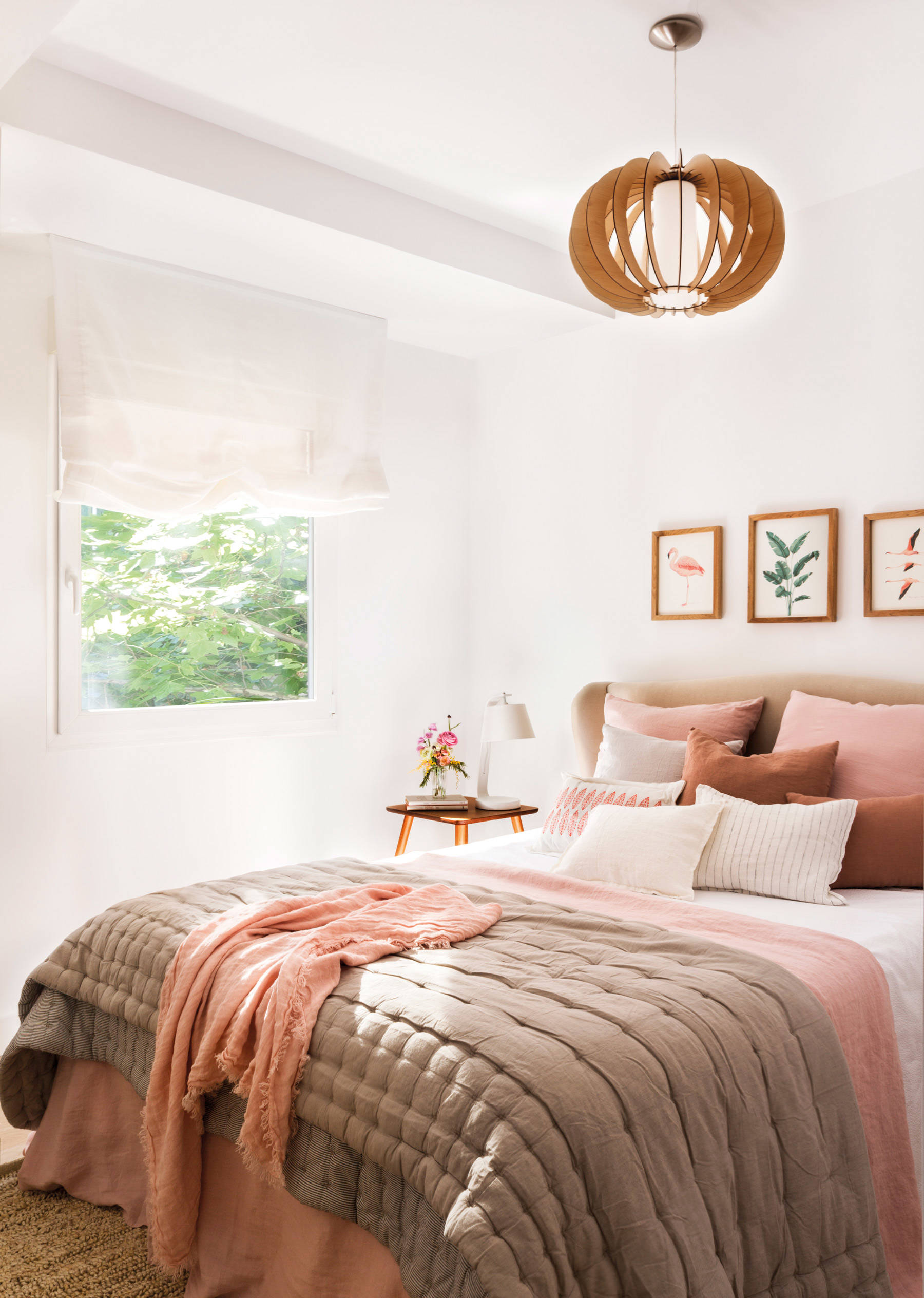 Dormitorio con ropa de cama rosa y topo. 