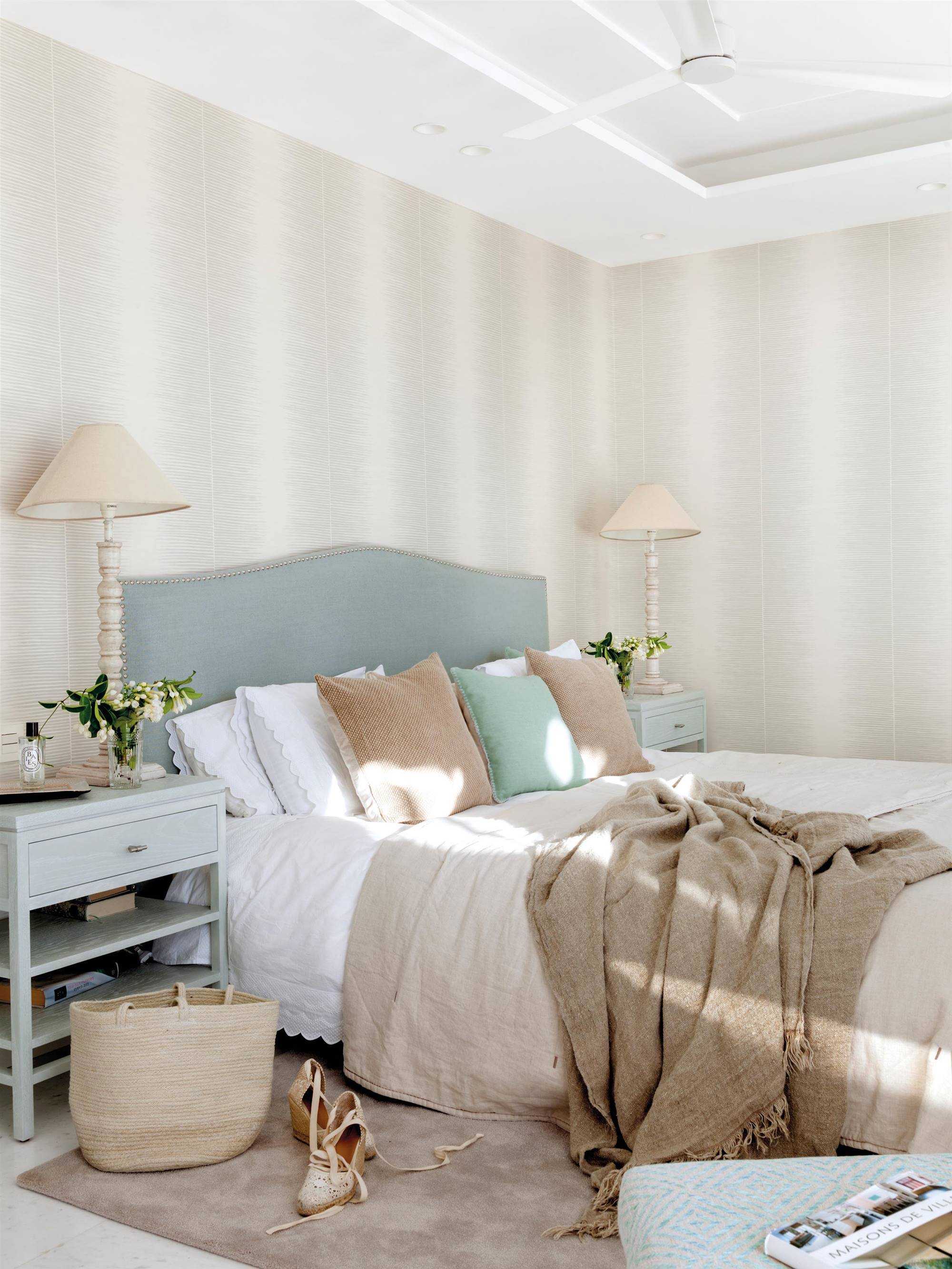 Dormitorio con papel pintado en la pared del cabecero. 