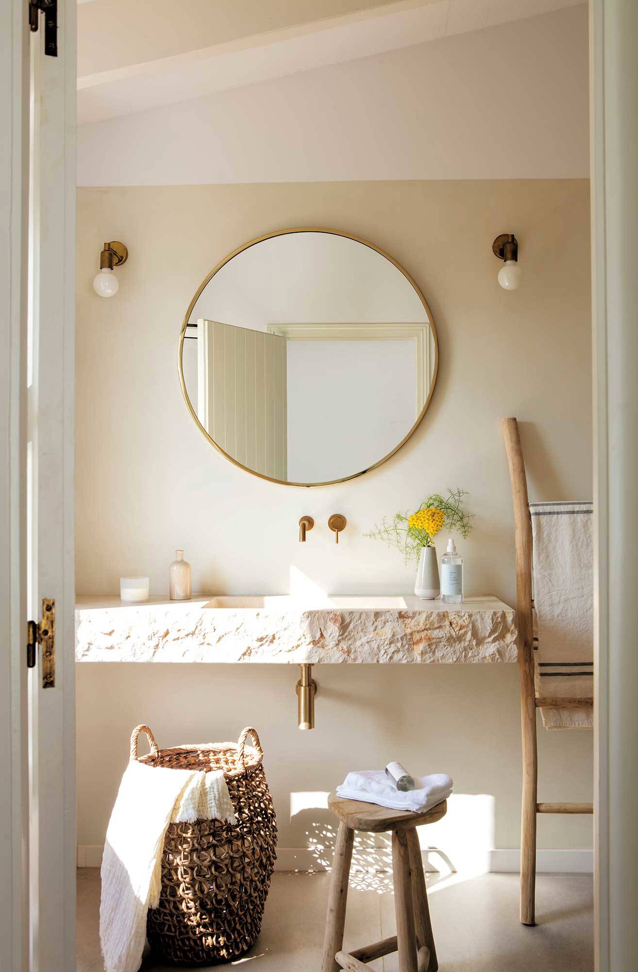 Baño con espejo con marco de madera.