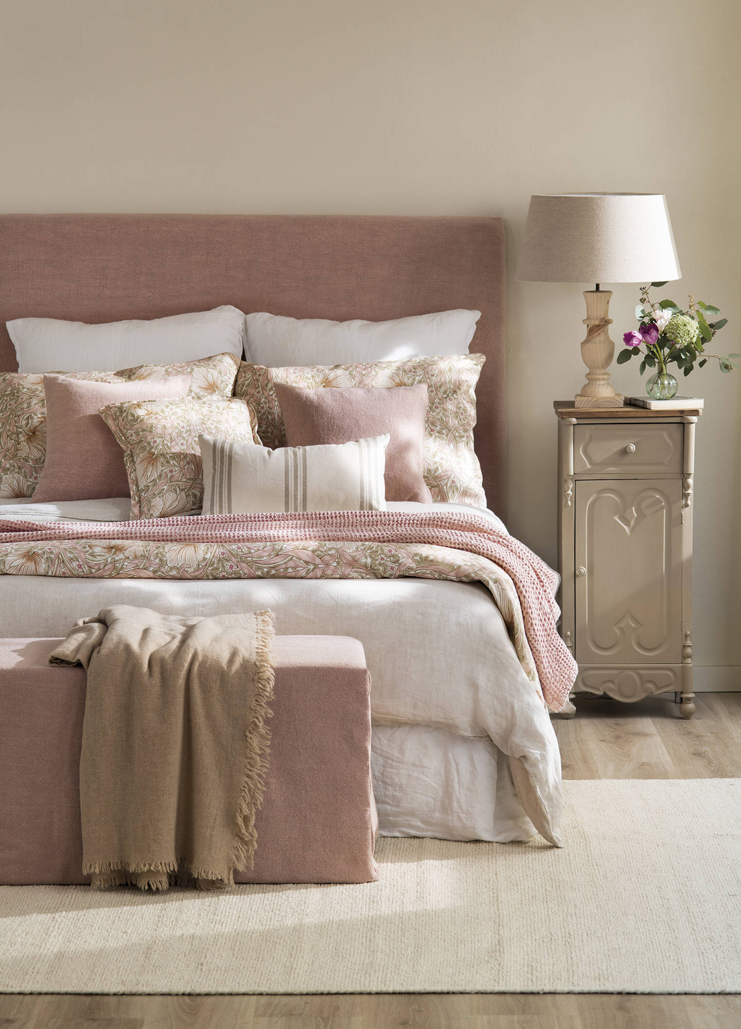 Dormitorio con cabecero tapizado rosa y ropa de cama a juego