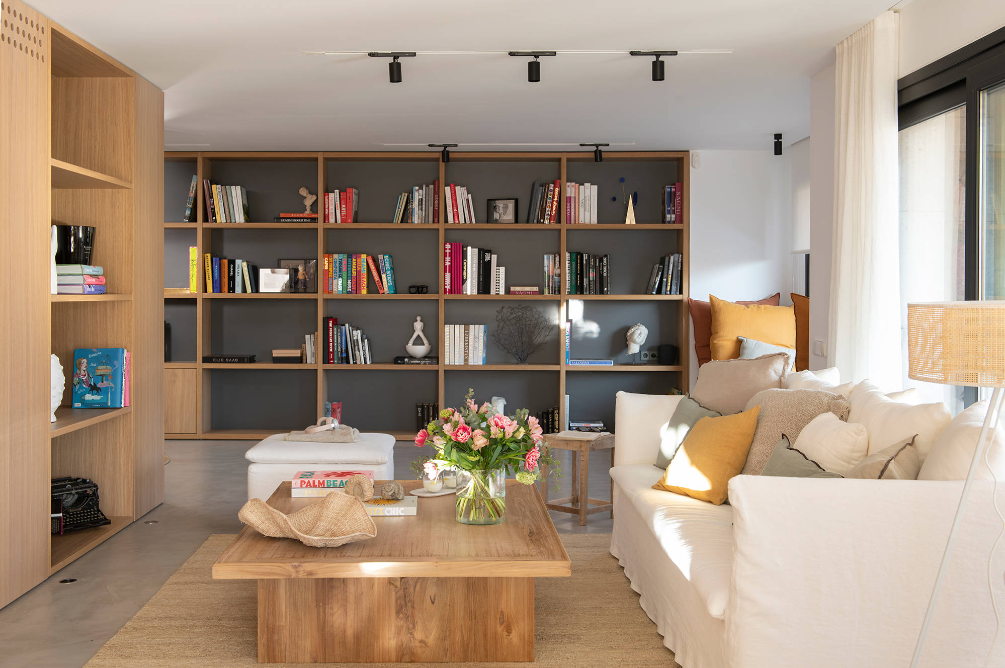 Salón pequeño con sofá blanco y muebles de madera