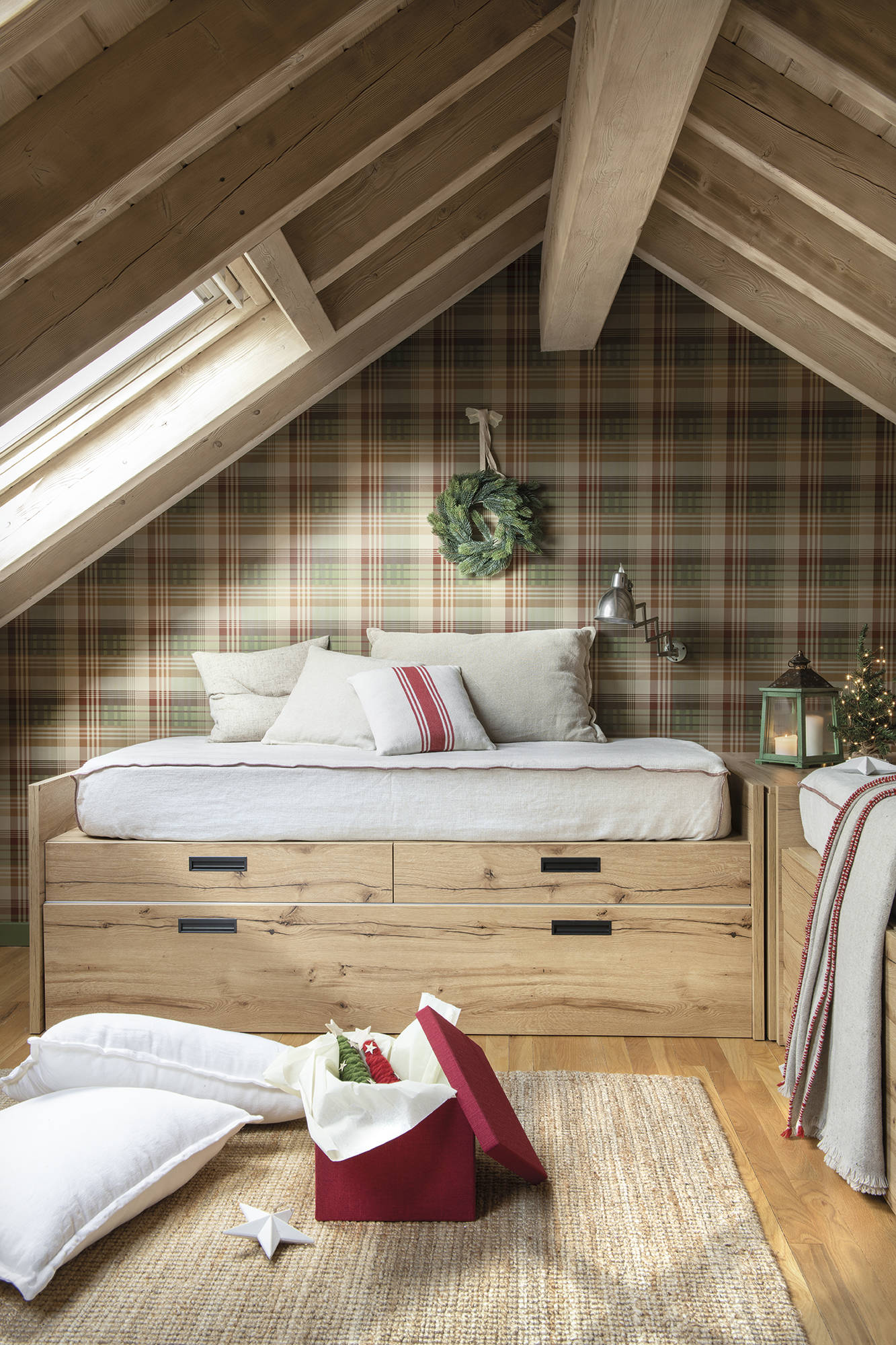 Dormitorio juvenil abuhardillado con papel pintado de caudros y dos camas de madera.