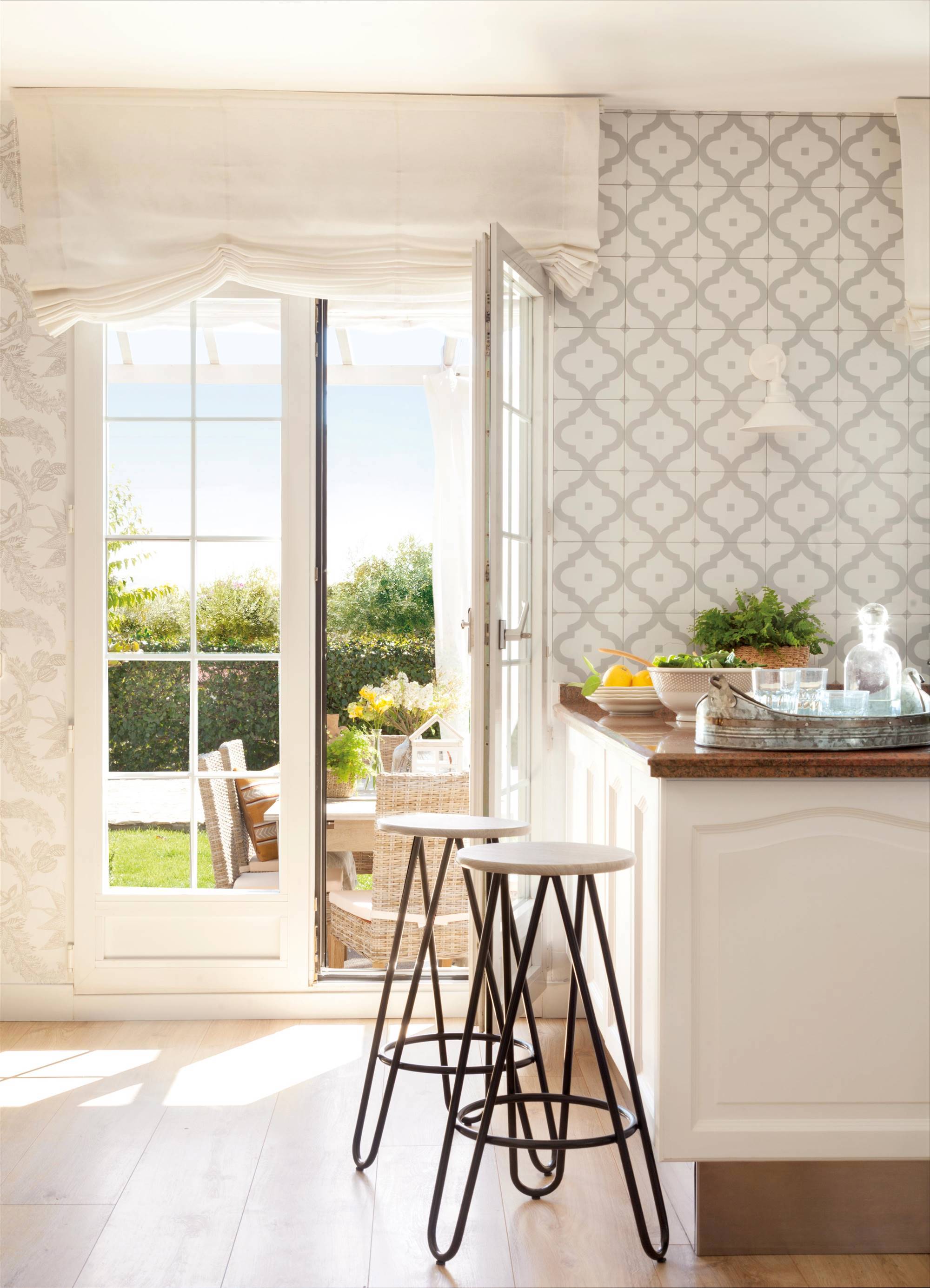Cocina blanca con pared de azulejos decorados.