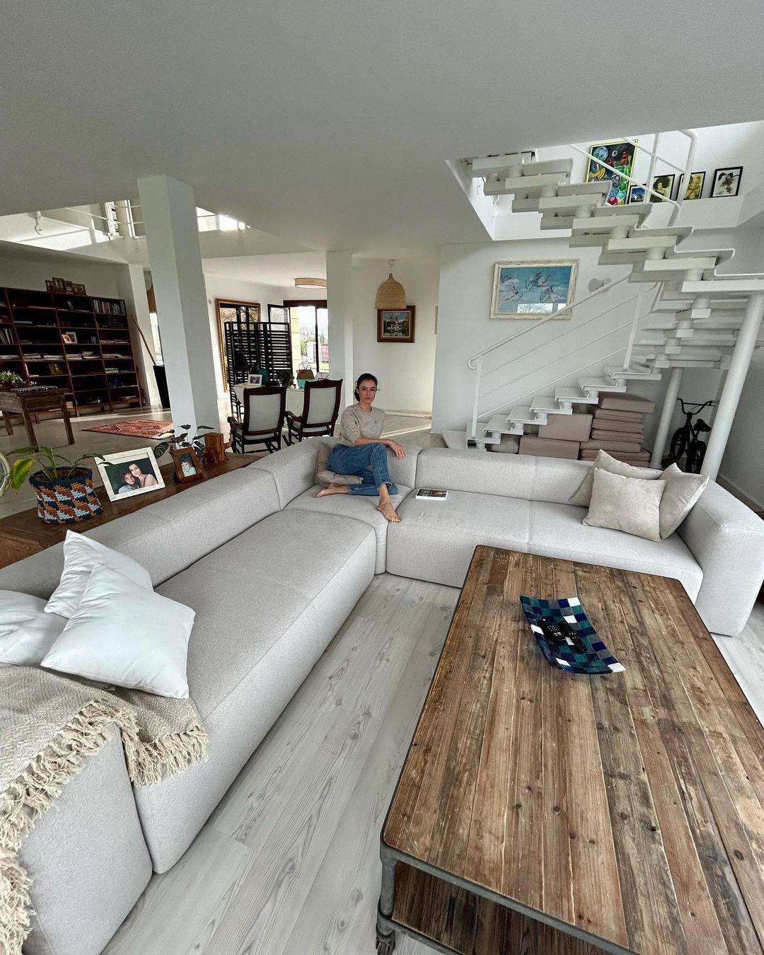 Salón con sofá modular gris para dividir los ambientes.