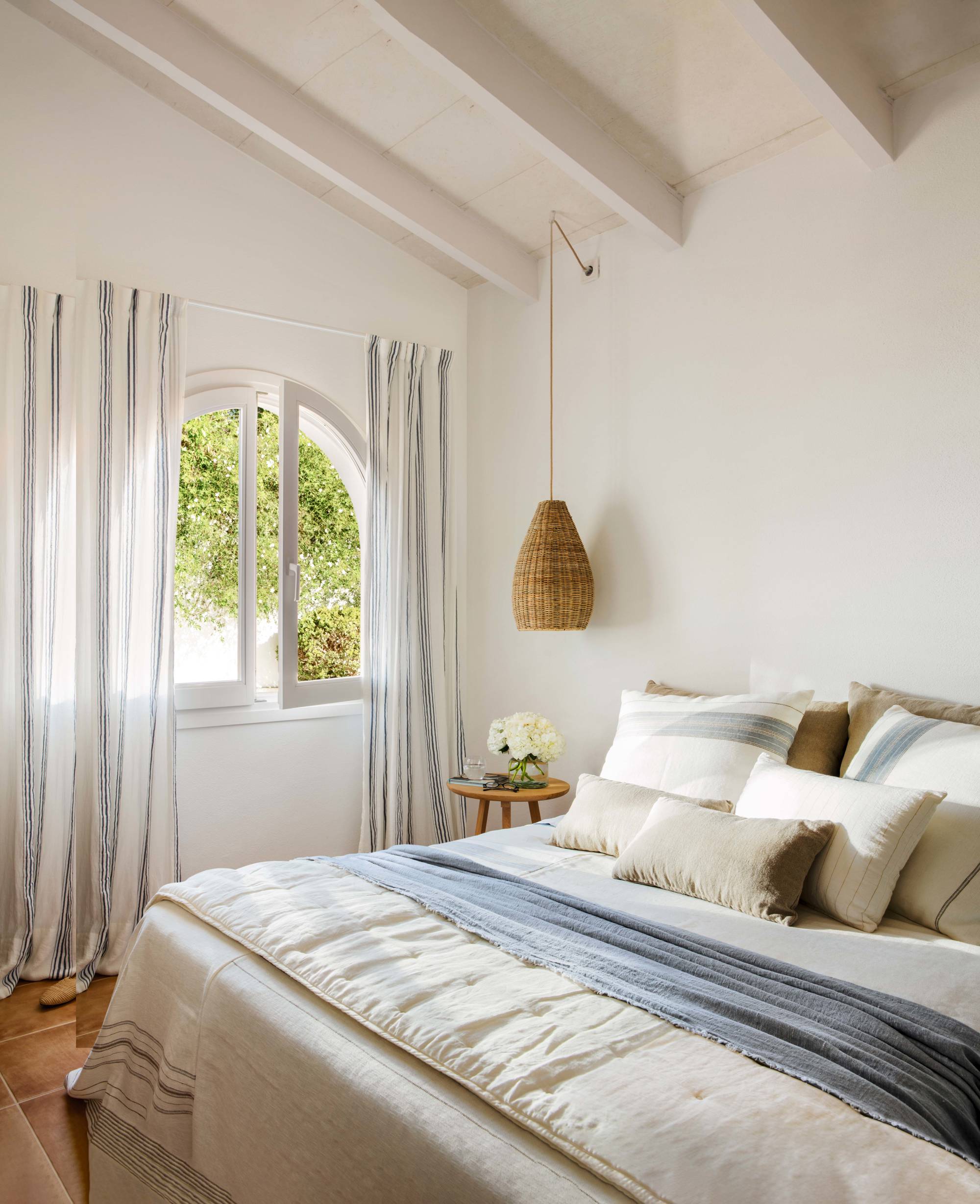 Dormitorio blanco con cortinas de rayas azules