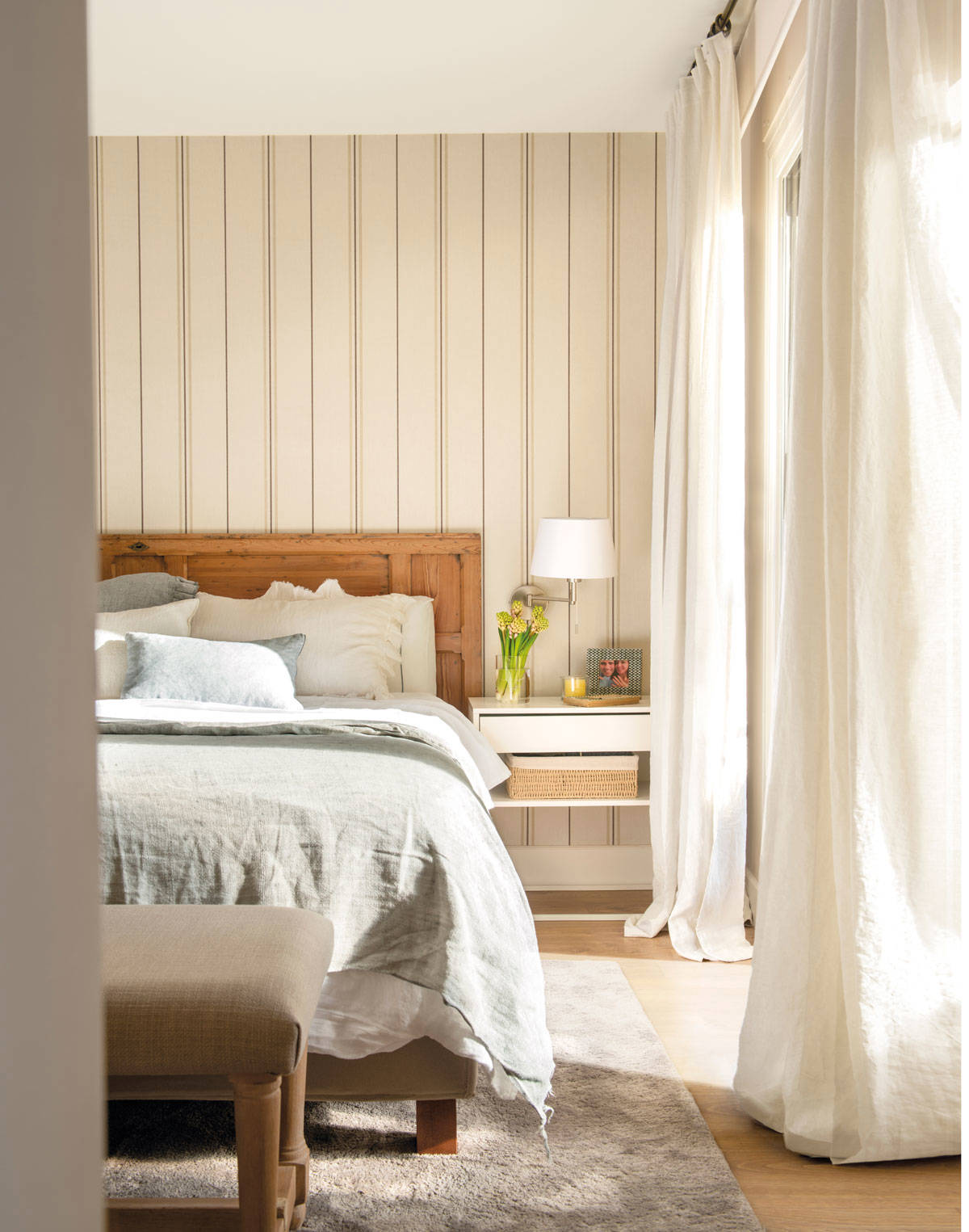 Dormitorio con papel pintado a rayas en la pared del cabecero 