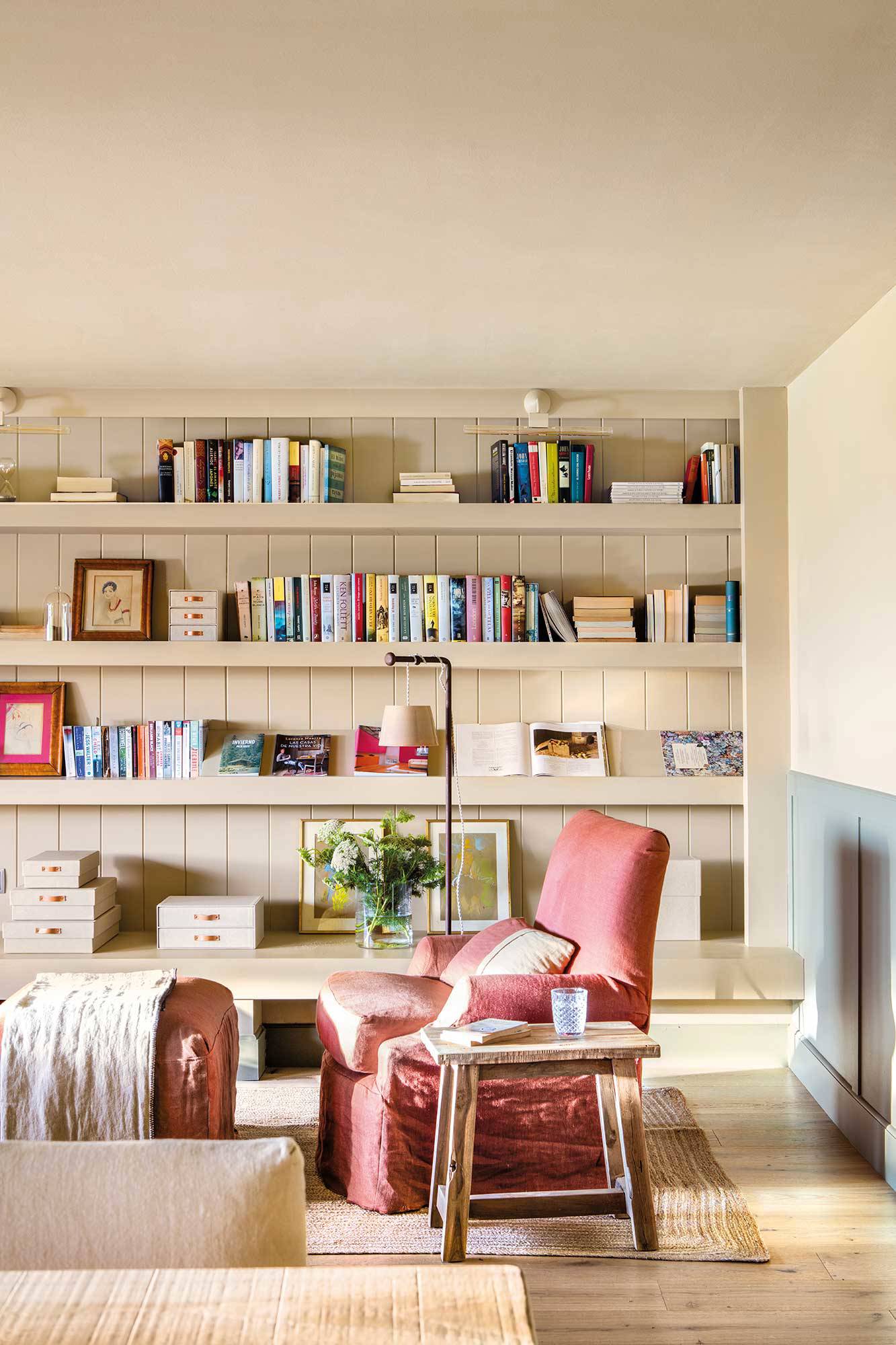 Salón con librería, butaca roja y arrimadero de color
