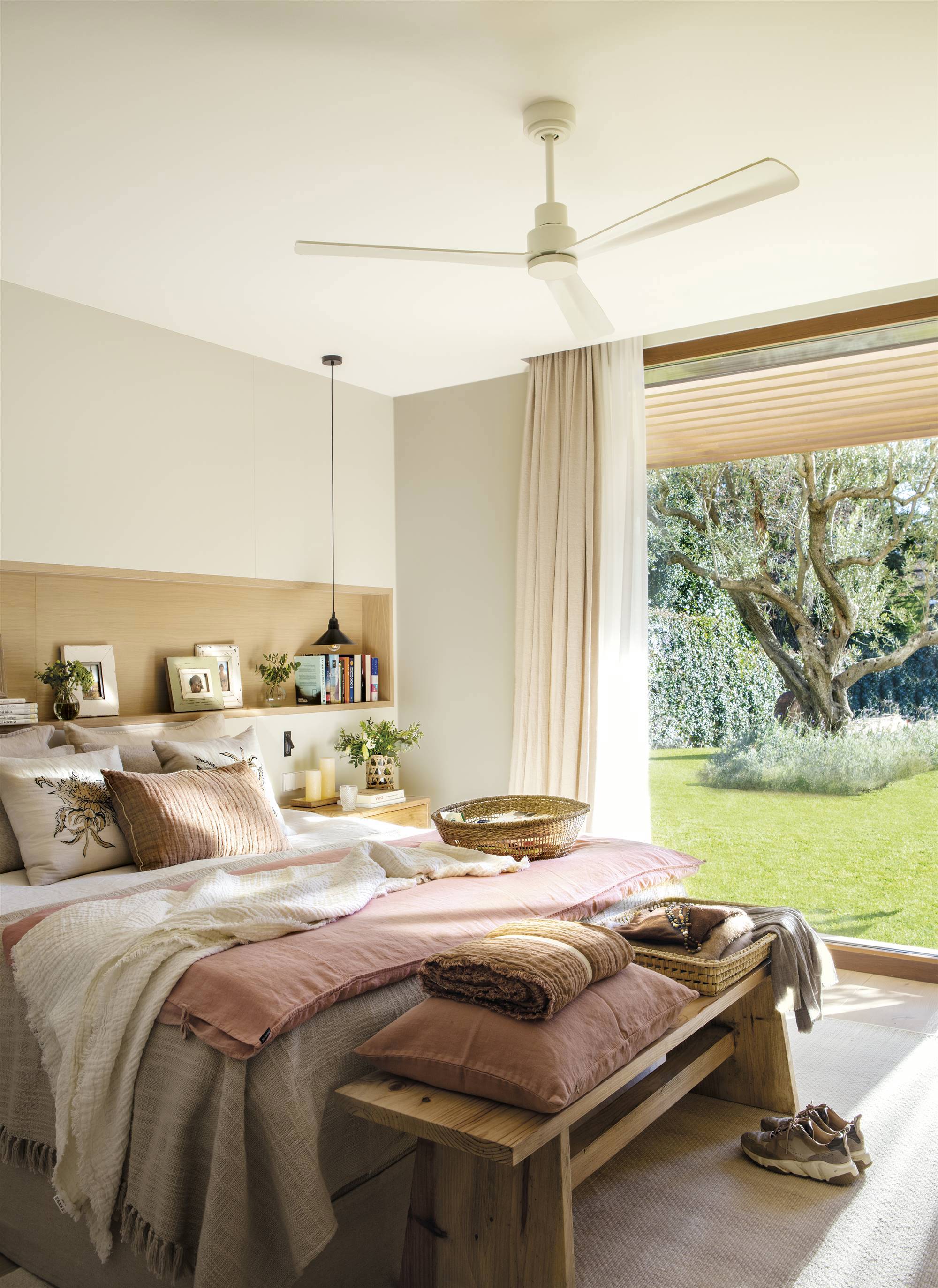 Dormitorio de primavera con cabecero en hornacina y ventilador de techo.