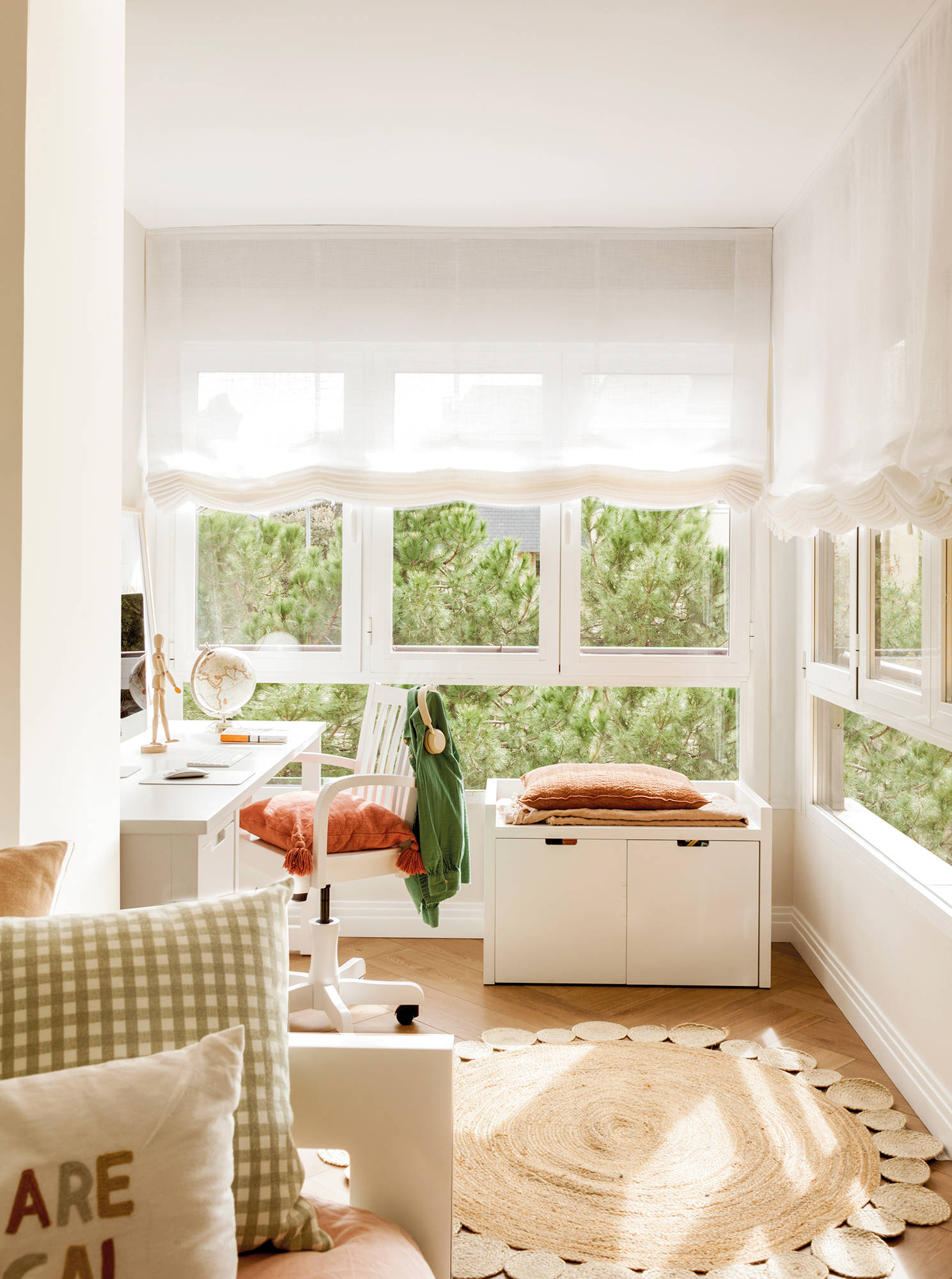 Dormitorio con ventanal, zócalo blanco y zona de escritorio.