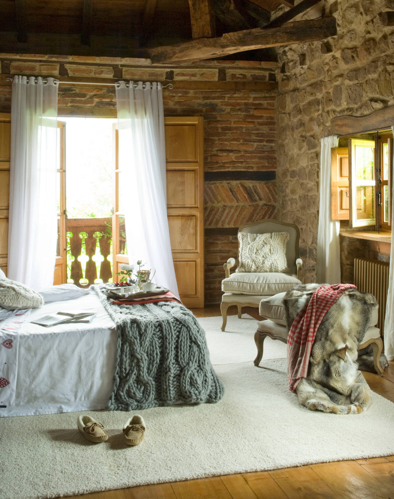Dormitorio con paredes rústicas en piedra y ladrillo.