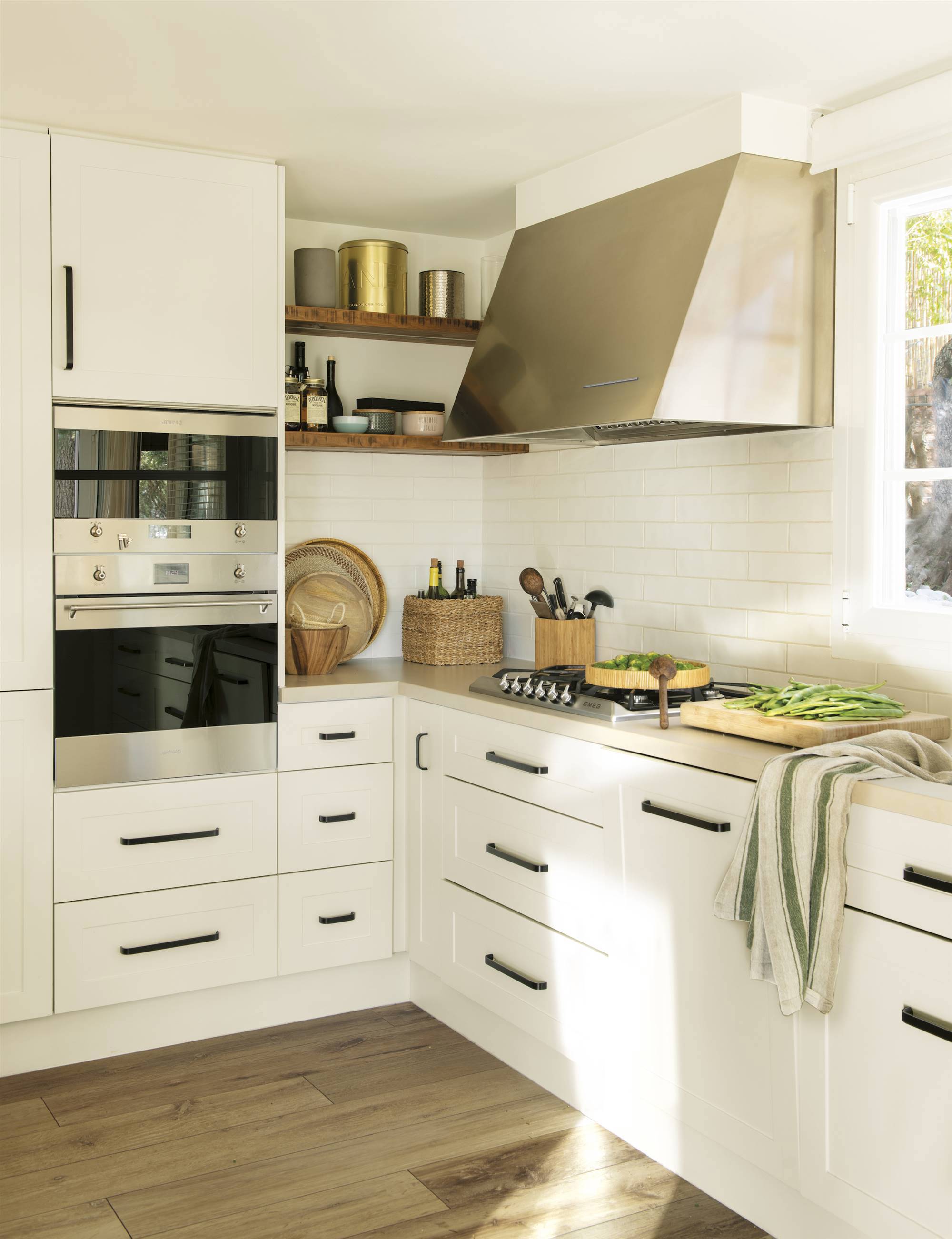 Small white kitchen with black handles and stainless steel hood 00553621
